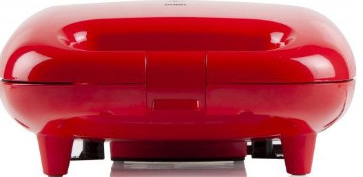 A red waffle maker, rounded design with a top lid, front view.