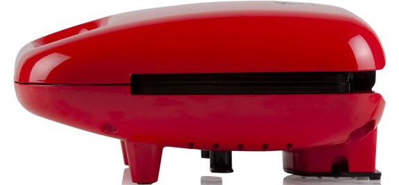 A red waffle maker, side view, with black interior, and small legs.