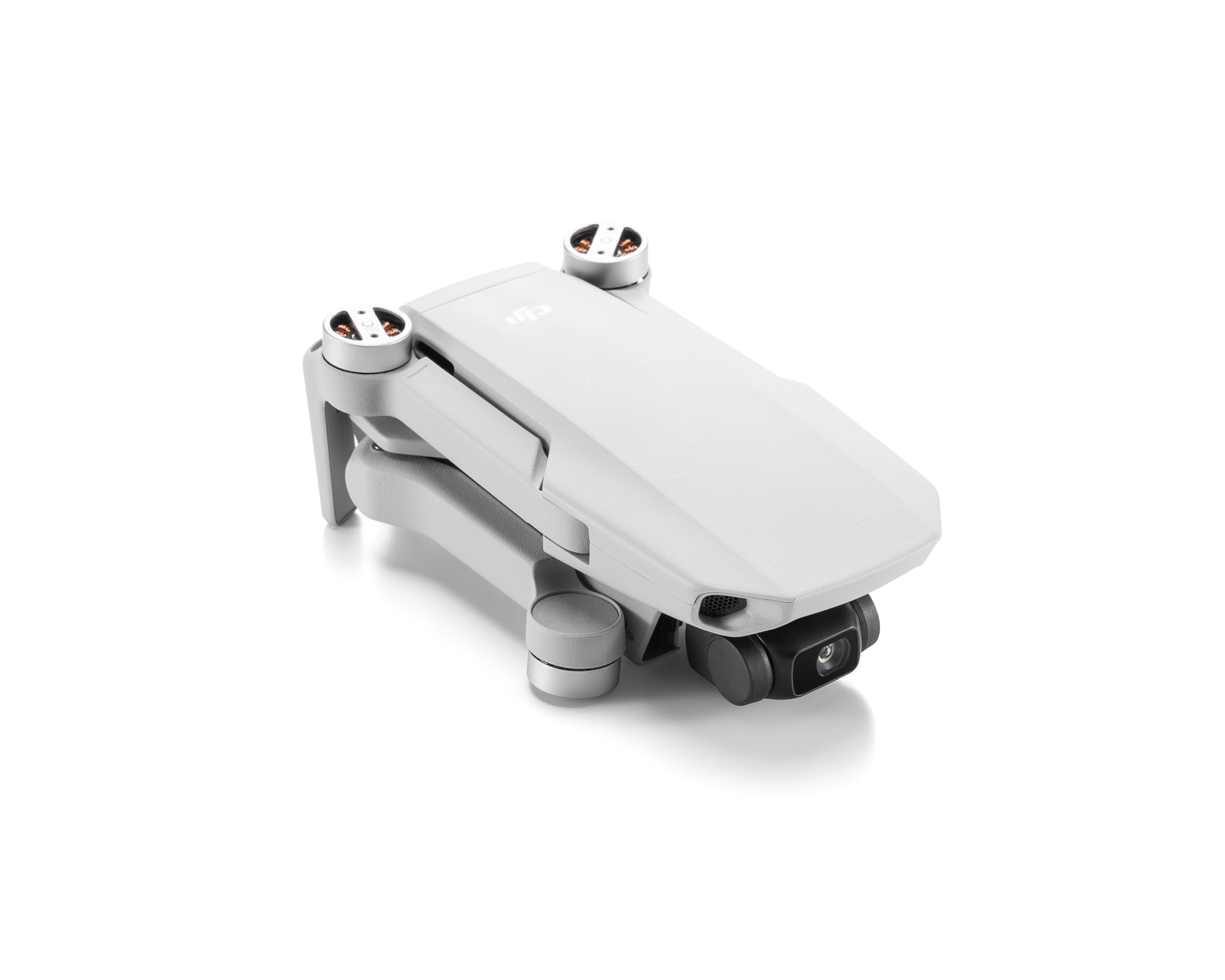 Fehér DJI Mini 2 drón fehér felületen. A drón össze van hajtva.
