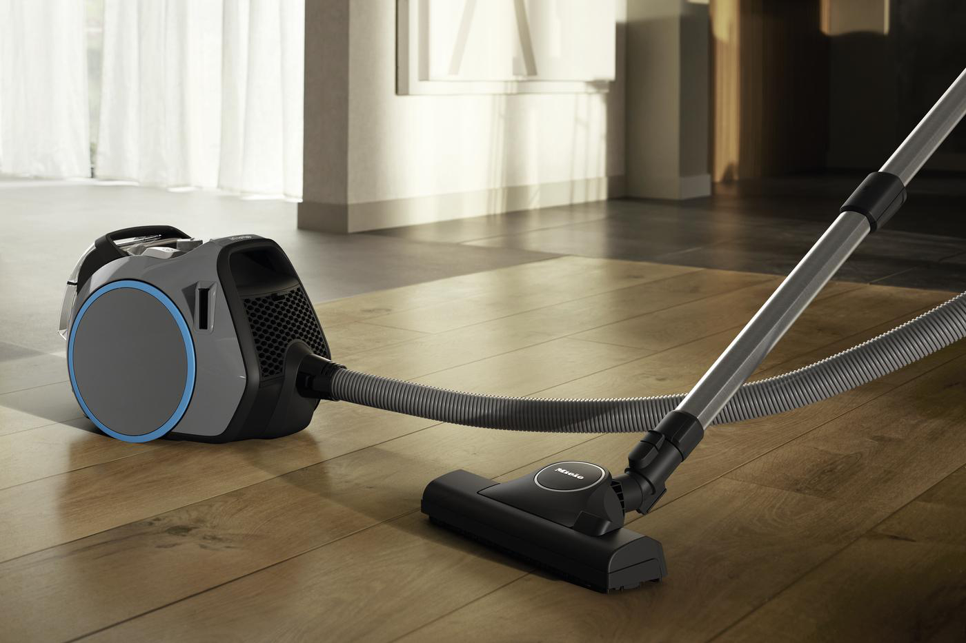 Staubsauger auf einem Holzboden, mit dem Staubsaugerkopf zum Reinigen positioniert.