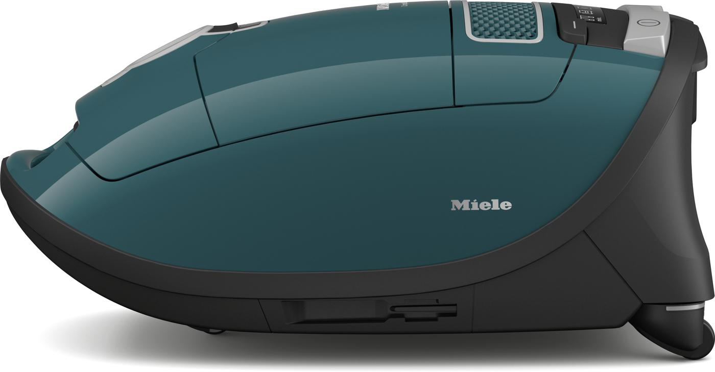Ein teal Miele Staubsauger, im Profil betrachtet. Es hat einen schwarzen Sockel.
