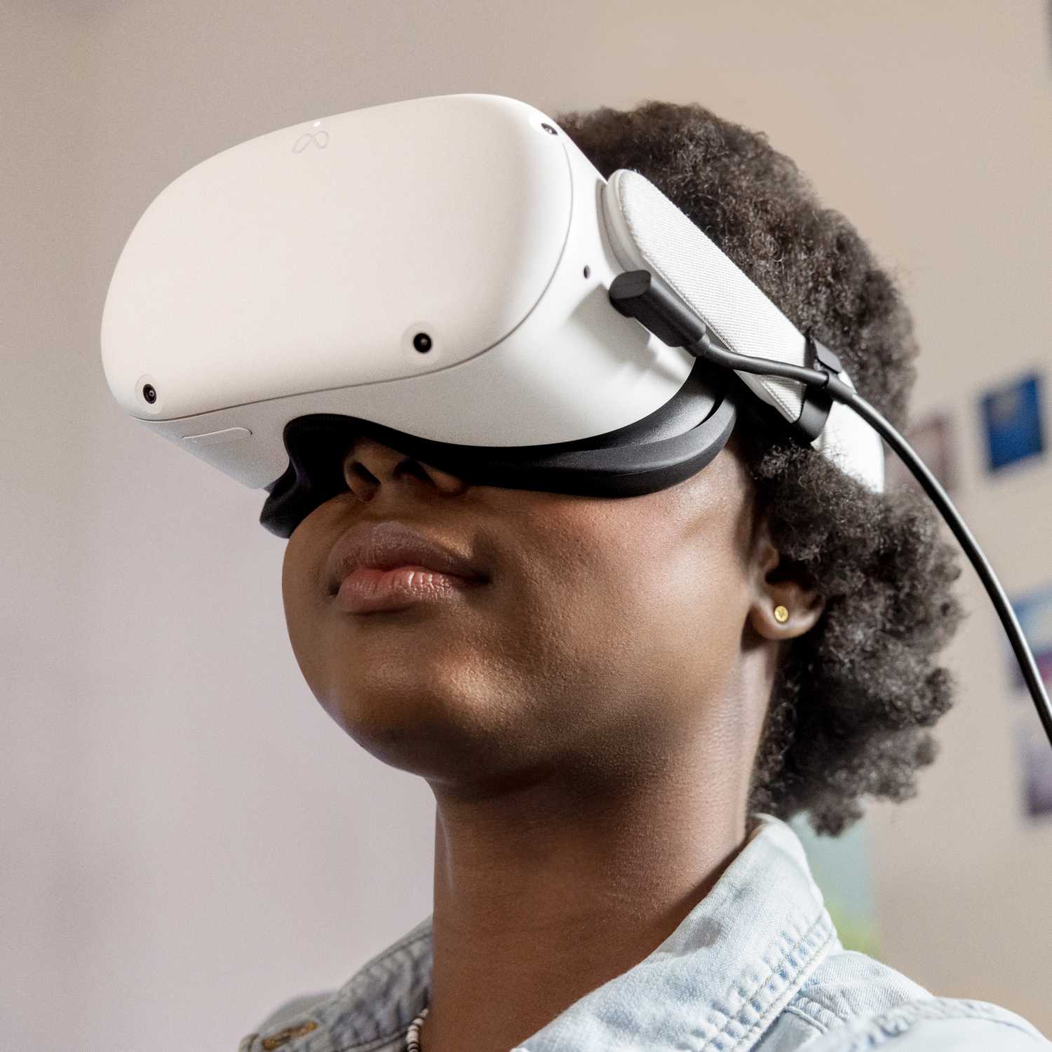 Una mujer con un casco de realidad virtual blanco mirando hacia arriba. El casco cubre sus ojos.