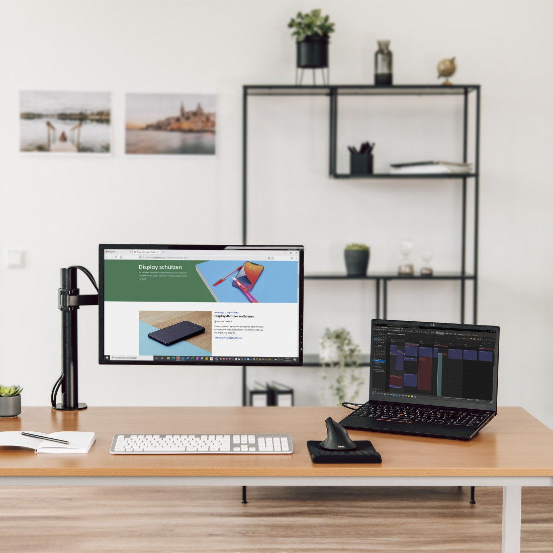 Espacio de trabajo con un monitor en un soporte, portátil, teclado y ratón.