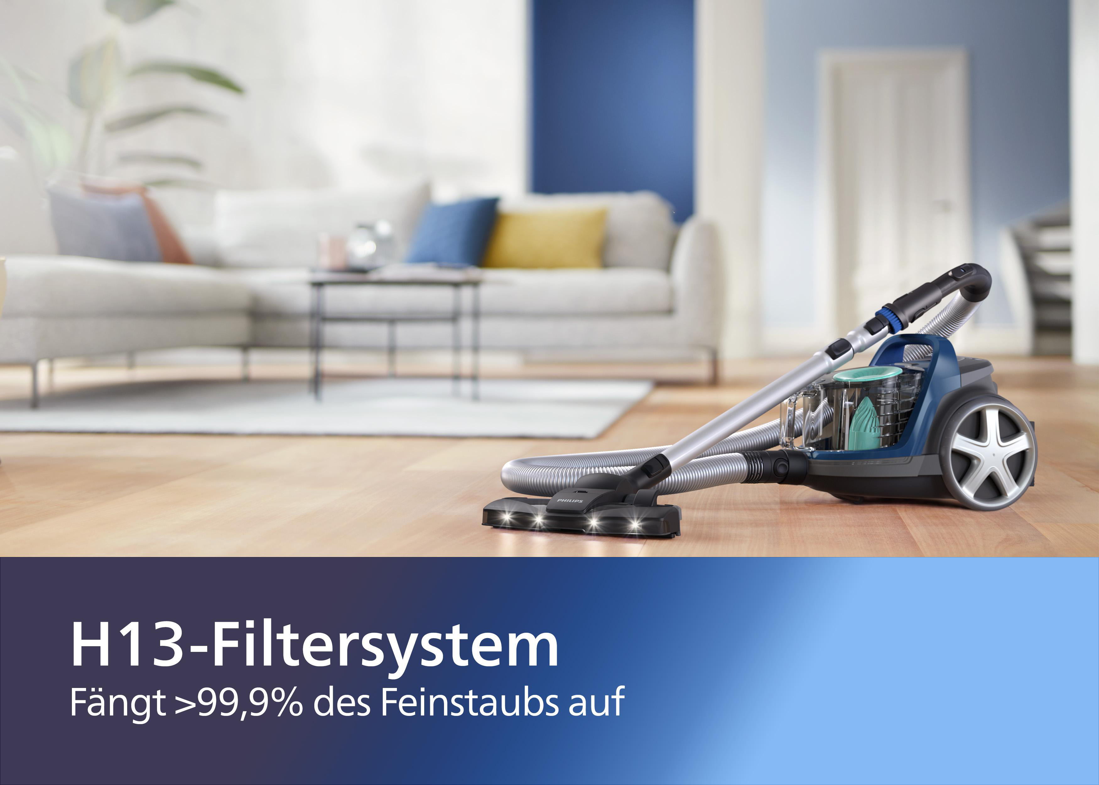 Staubsauger auf Holzboden. Sofa im Hintergrund. Text unten.
