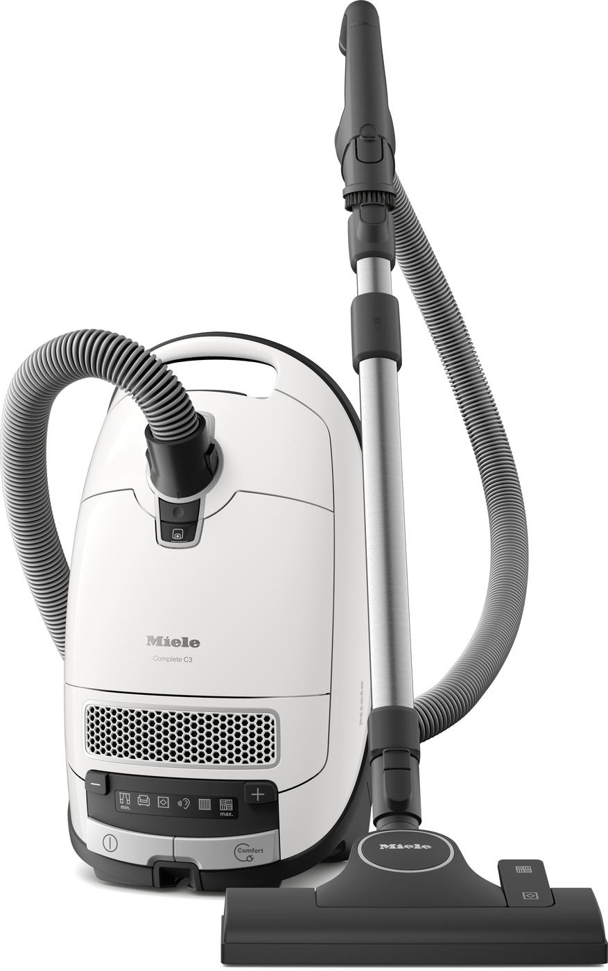 Weißer Miele Complete C3 Staubsauger. Schwarzer Schlauch und Aufsätze. Der Staubsauger ist aufrecht.