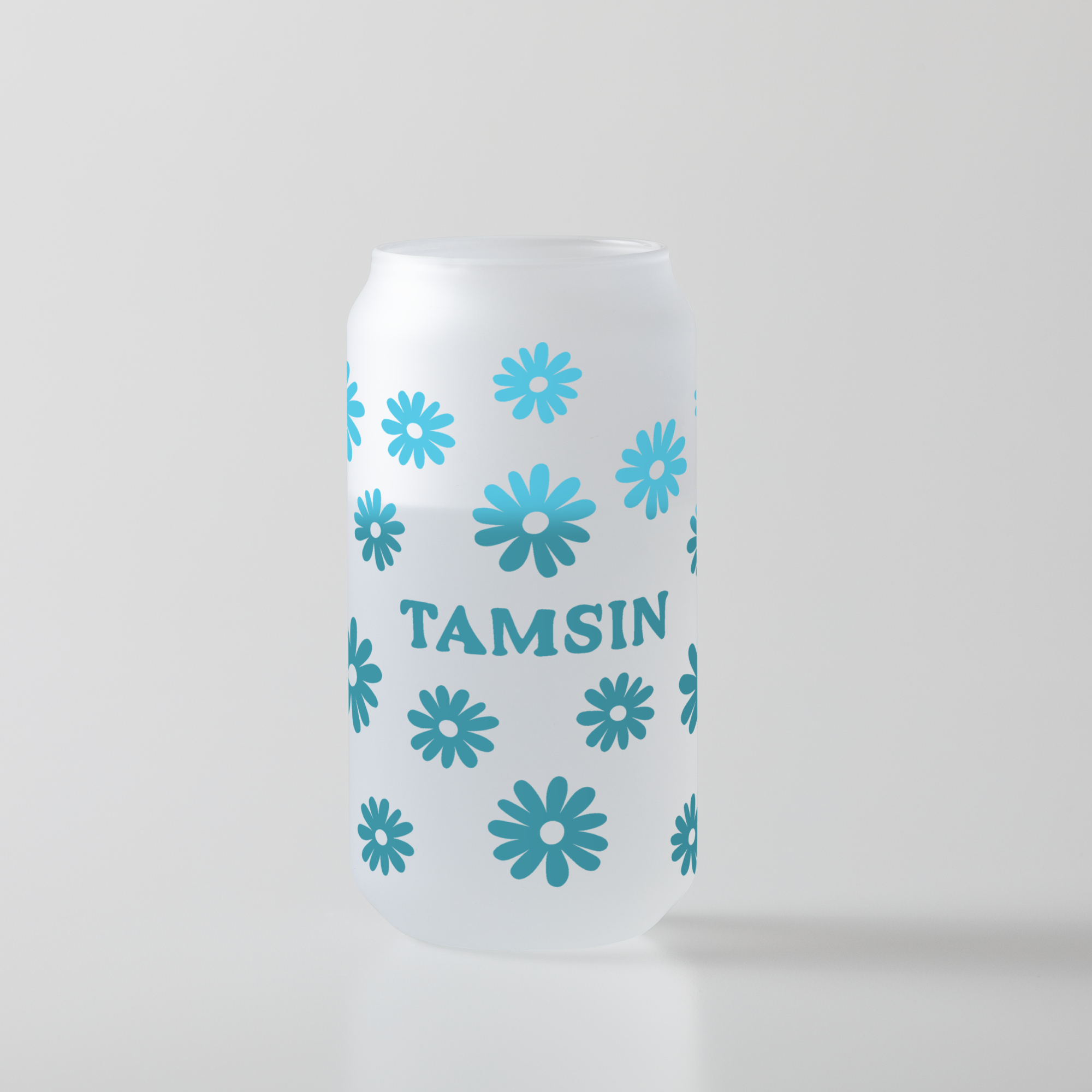 Eine weiße, satinierte Glasdose mit blauen Blumenillustrationen und dem Wort 'TAMSIN'.