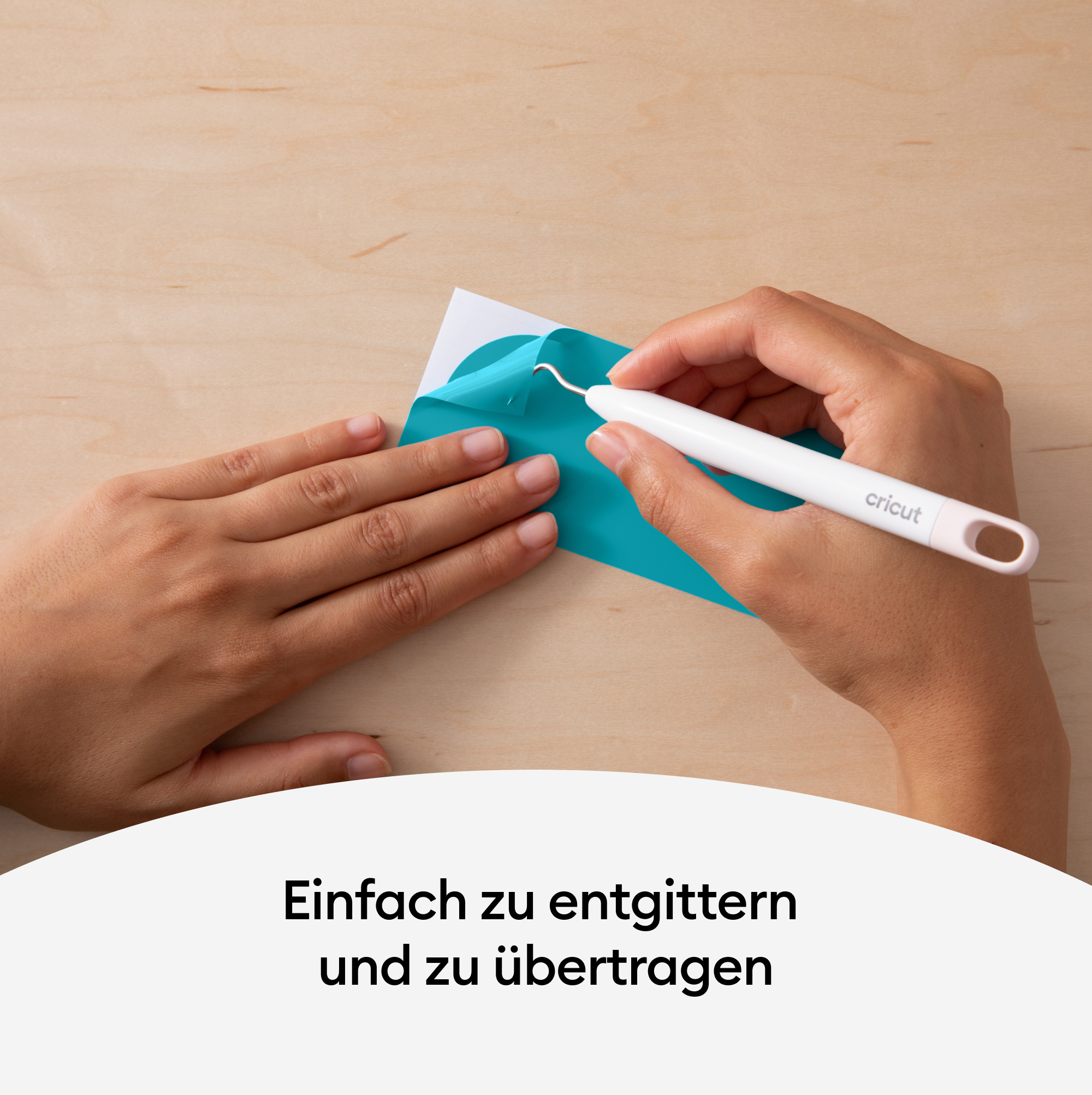 Hände halten ein türkisfarbenes Material, schneiden mit einem weißen Cricut-Werkzeug auf Holz.