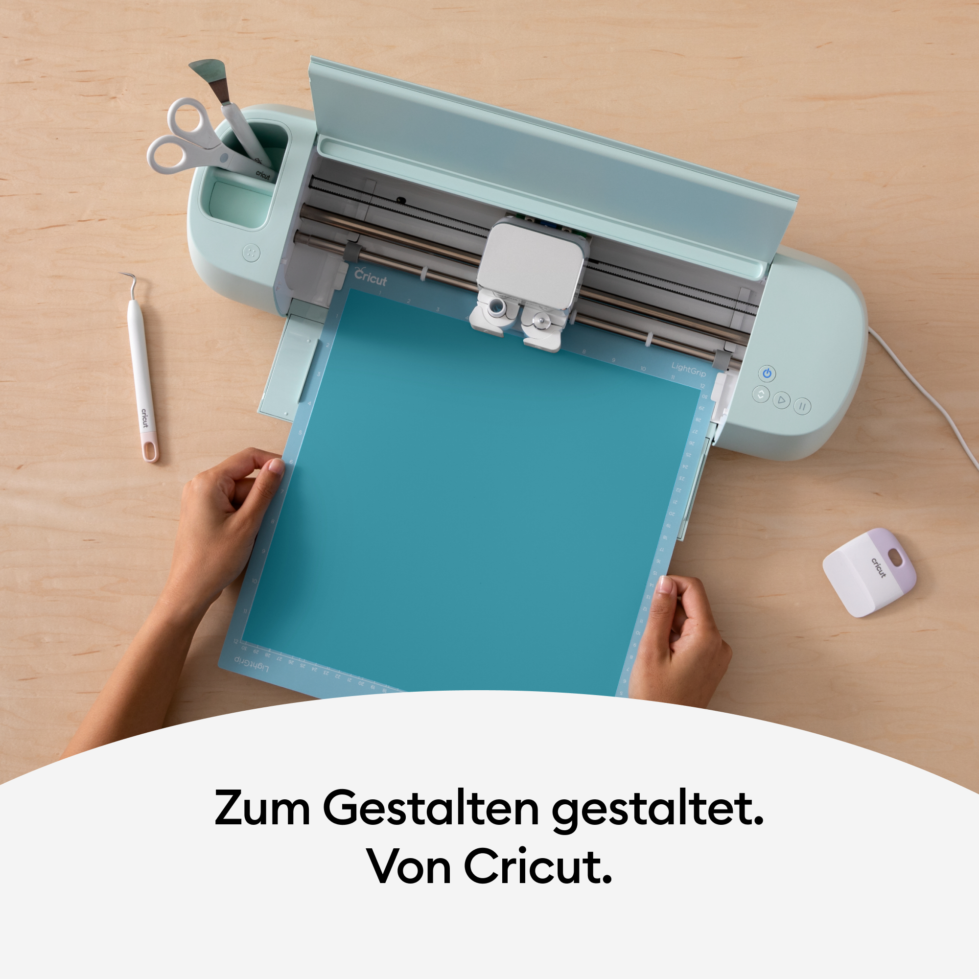 Eine Cricut-Maschine und ein blaues Blatt auf einem Holztisch.