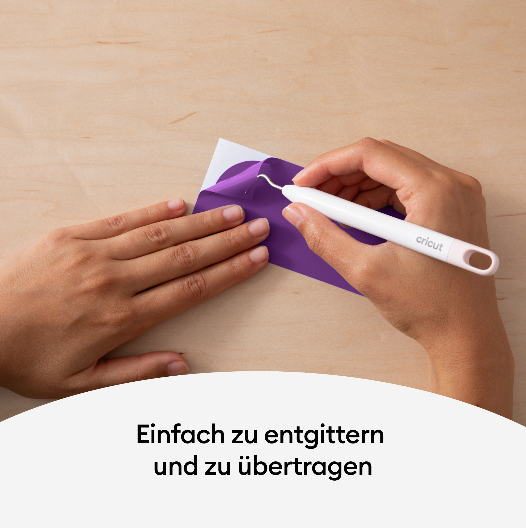 Hände, die ein Cricut-Werkzeug verwenden, um violettes Vinyl von weißem Träger zu lösen, auf Holz.