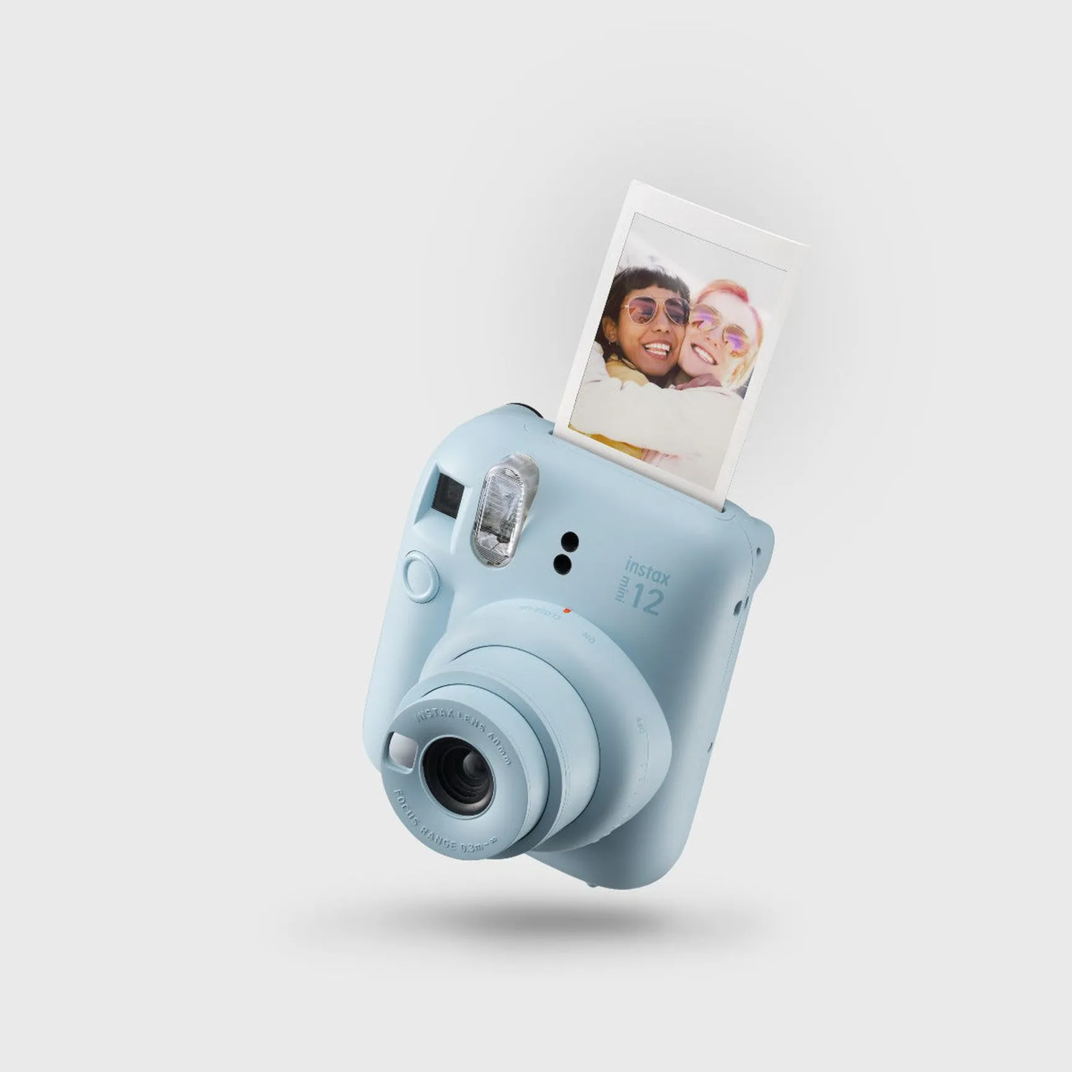 Un appareil photo Instax bleu clair avec une photo montrant deux femmes souriantes.