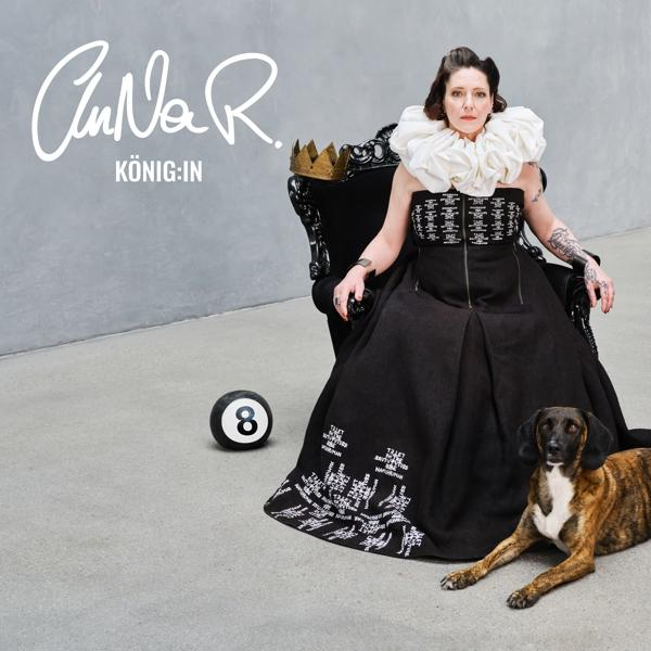 Frau in schwarzem Kleid auf Thron, Hund und 8-Ball. Text: AnNa R. König:in.