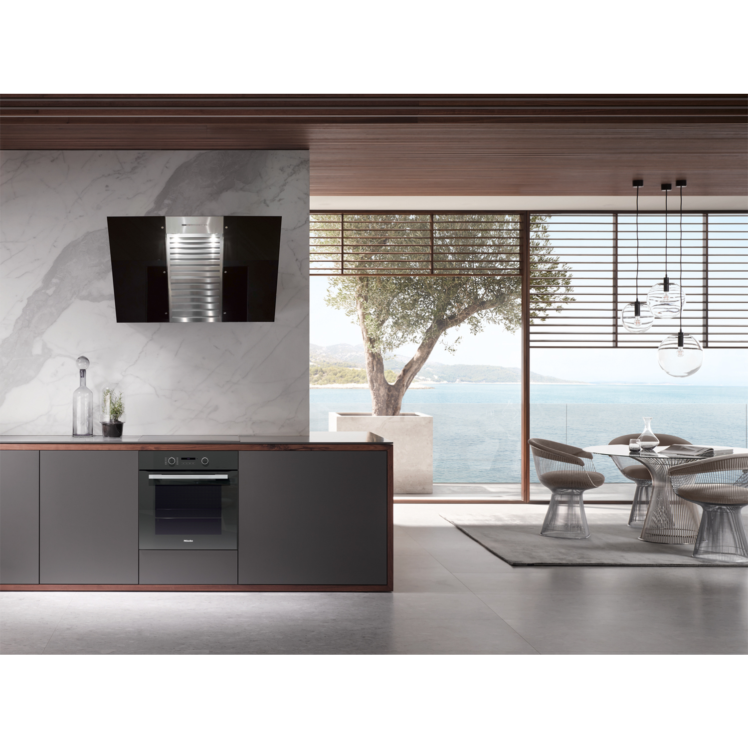 Interni cucina moderna con parete in marmo e mobili scuri.