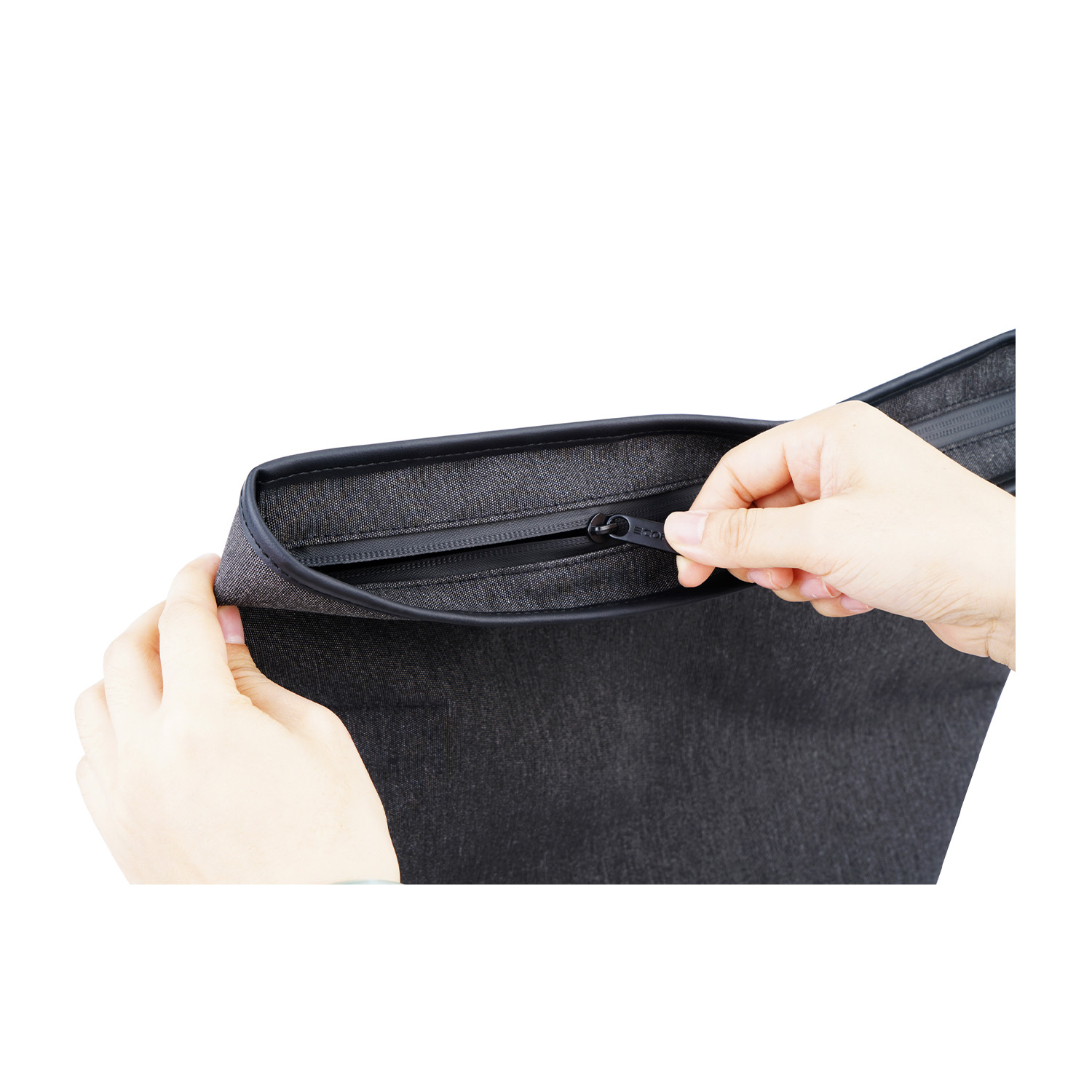 Mani che chiudono una borsa nera con la zip, isolata su sfondo bianco.