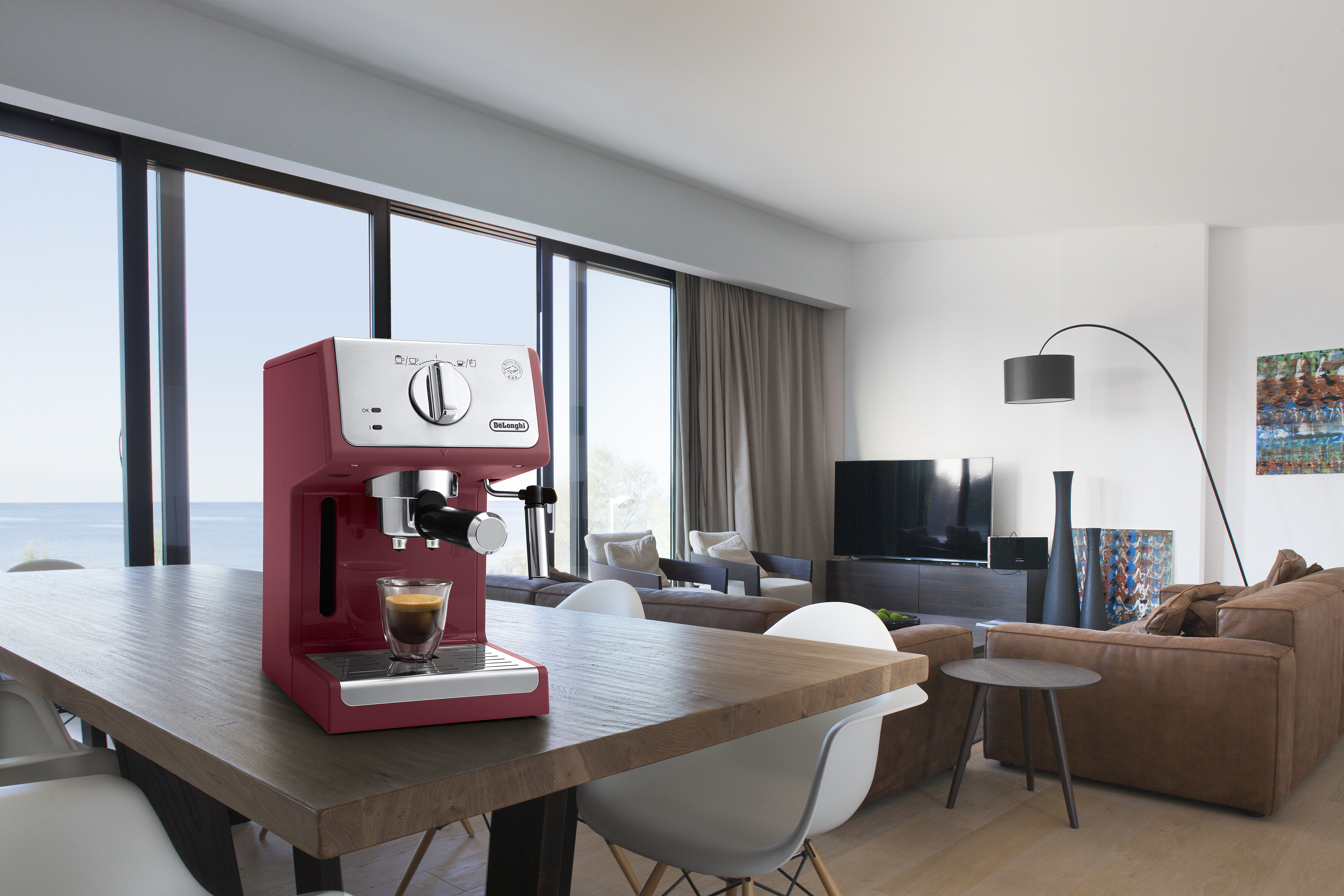 Máquina de espresso roja en mesa de sala.