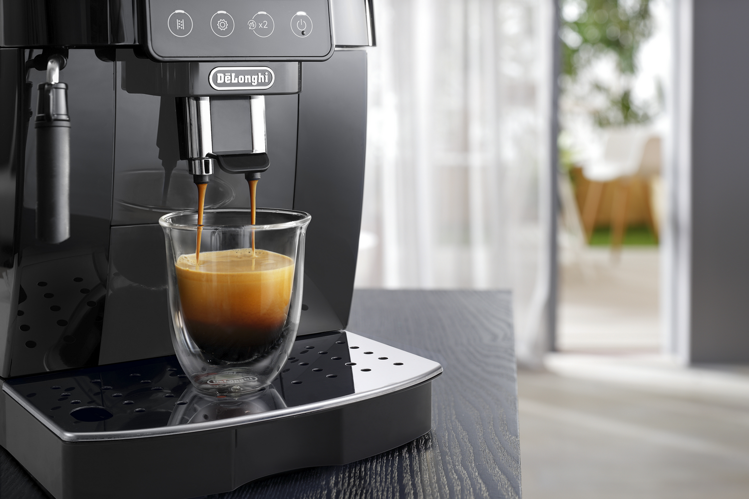 Máquina de espresso llenando una taza de café, sobre una superficie negra.