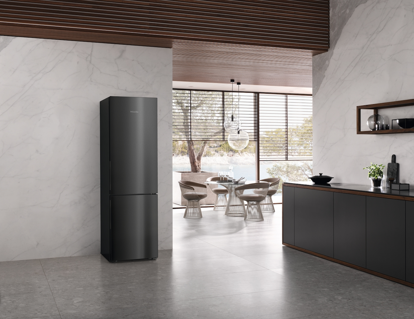 Moderne Küche mit schwarzem Kühlschrank, Essbereich und Blick nach draußen.