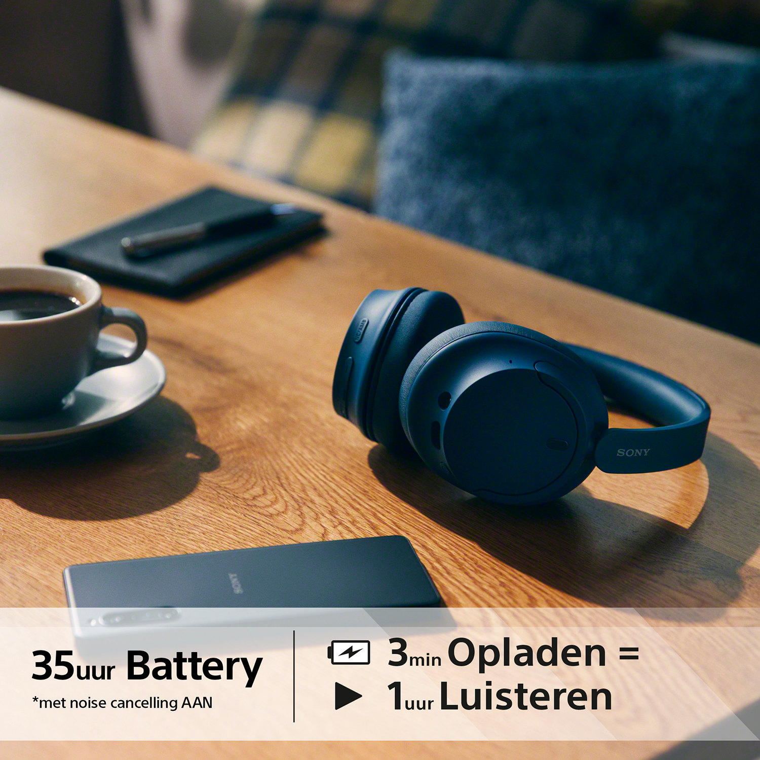 Headphones, a phone, and a coffee cup on a wooden table. Text indicates 35 hours battery.