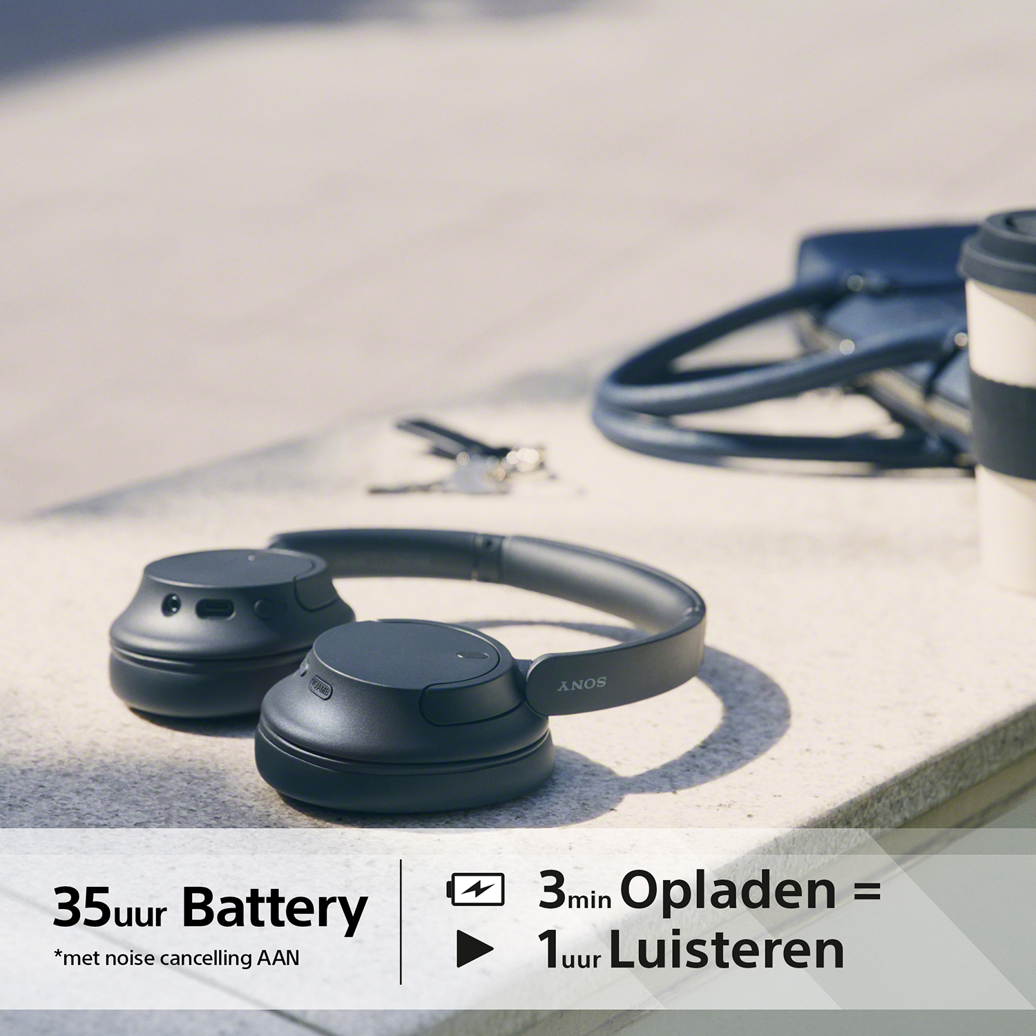 Zwarte koptelefoon op een oppervlak. Tekst vermeldt 35 uur batterij en 3 minuten opladen = 1 uur luisteren.