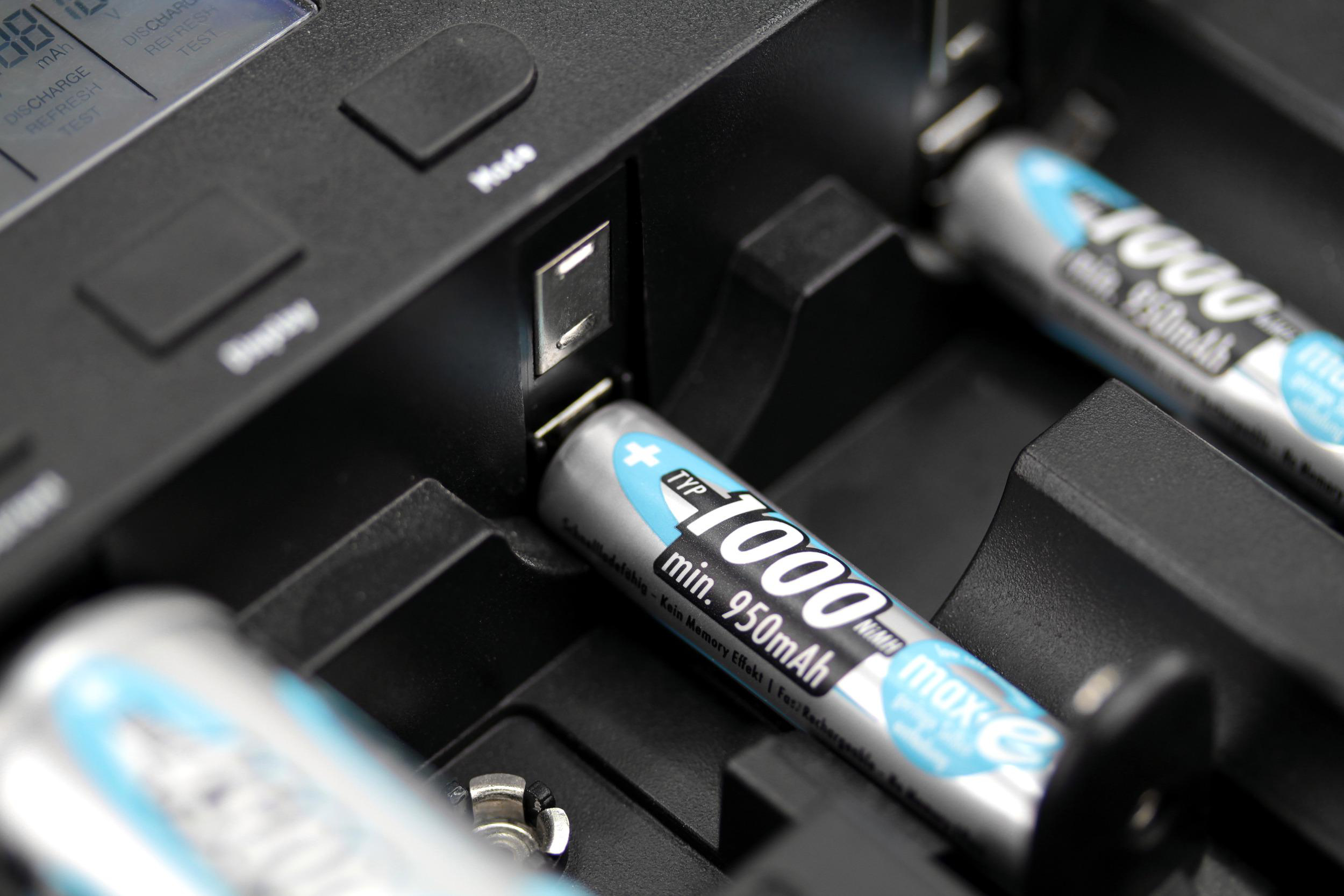 Nahaufnahme eines Batterieladegeräts mit eingelegten Batterien. Die Batterien sind zylindrisch.