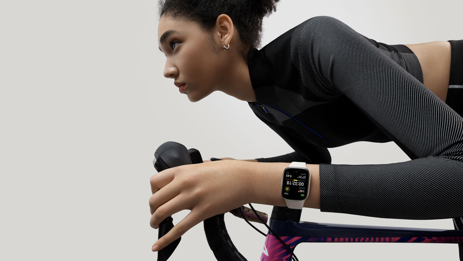 Una mujer con un reloj inteligente en una bicicleta está montando en bicicleta.