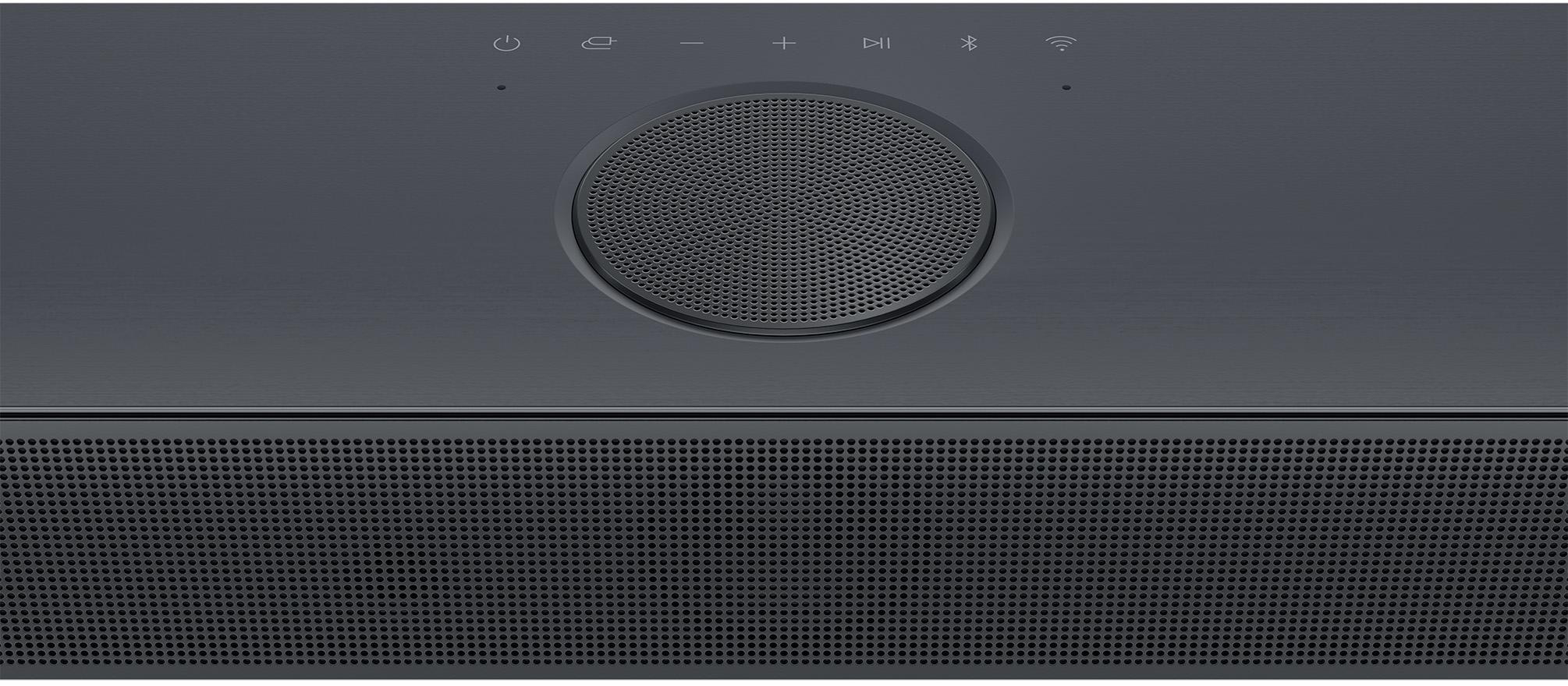 Nahaufnahme einer schwarzen Soundbar. In der Mitte befindet sich ein kreisförmiger Lautsprecher und andere Knöpfe.