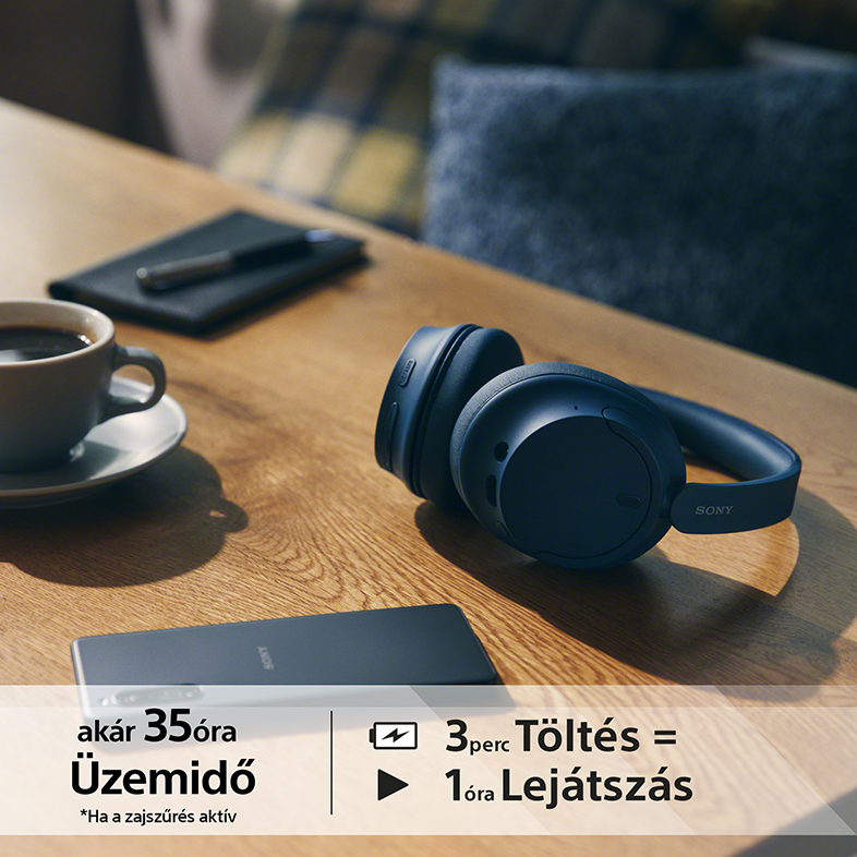 Fejhallgató faasztalon, telefon, kávé és jegyzetfüzet mellett.
