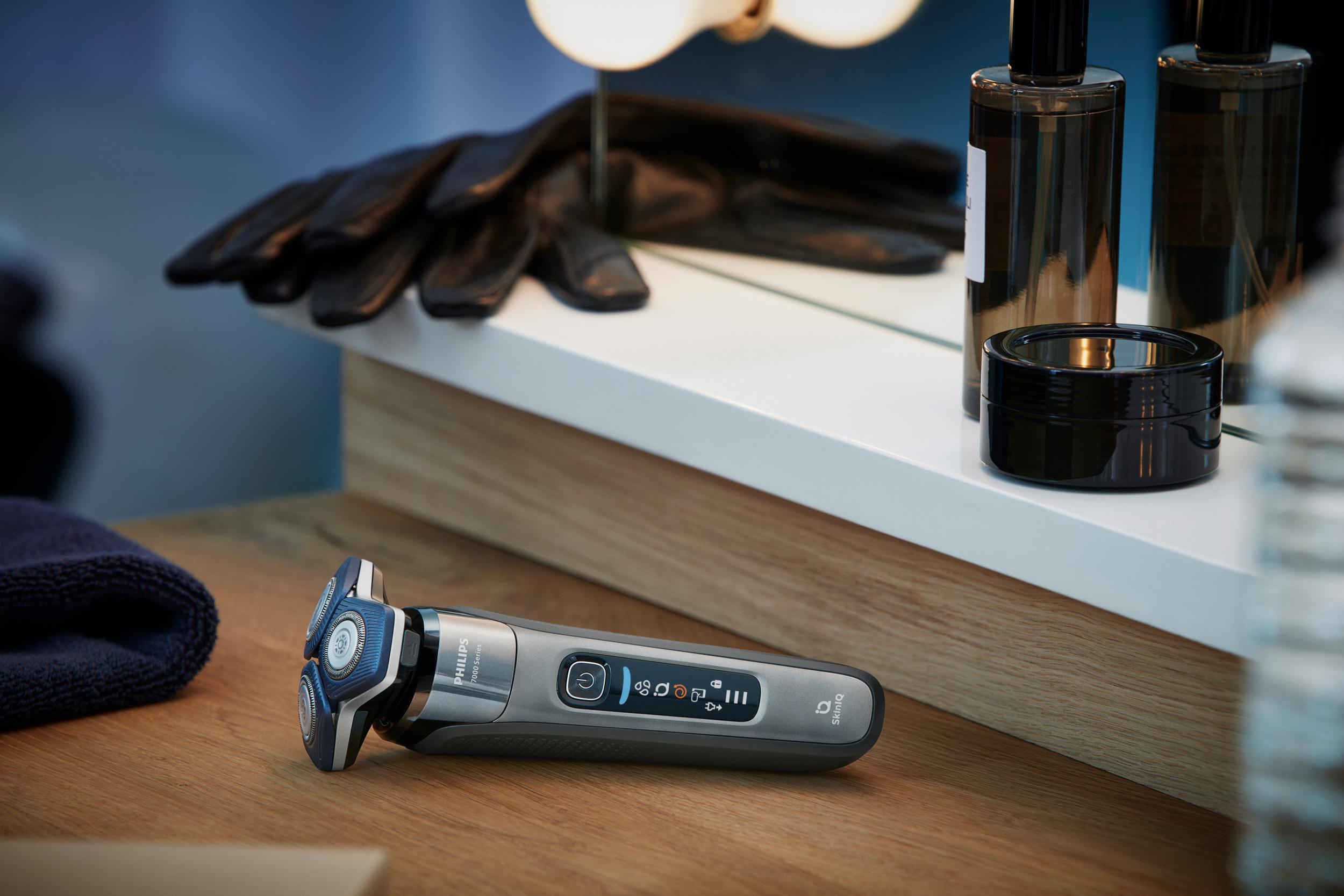 Ein Philips-Rasierer auf einer Holzoberfläche, in der Nähe von Pflegeprodukten.