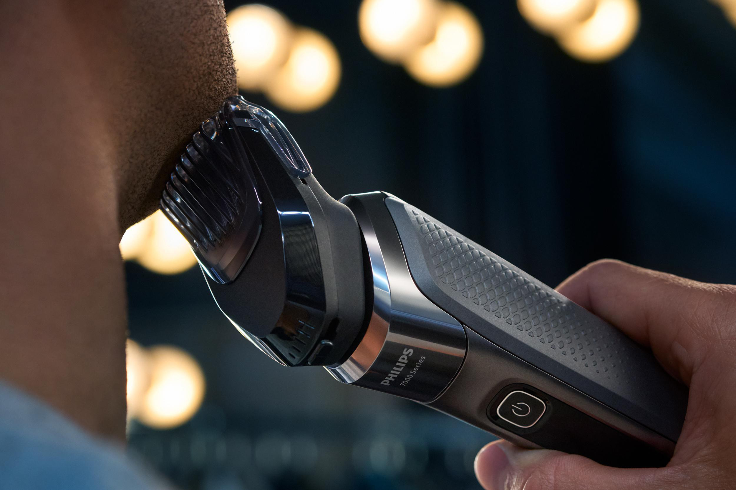 Nahaufnahme: Ein Mann rasiert seinen Hals mit einem elektrischen Rasierer von Philips.