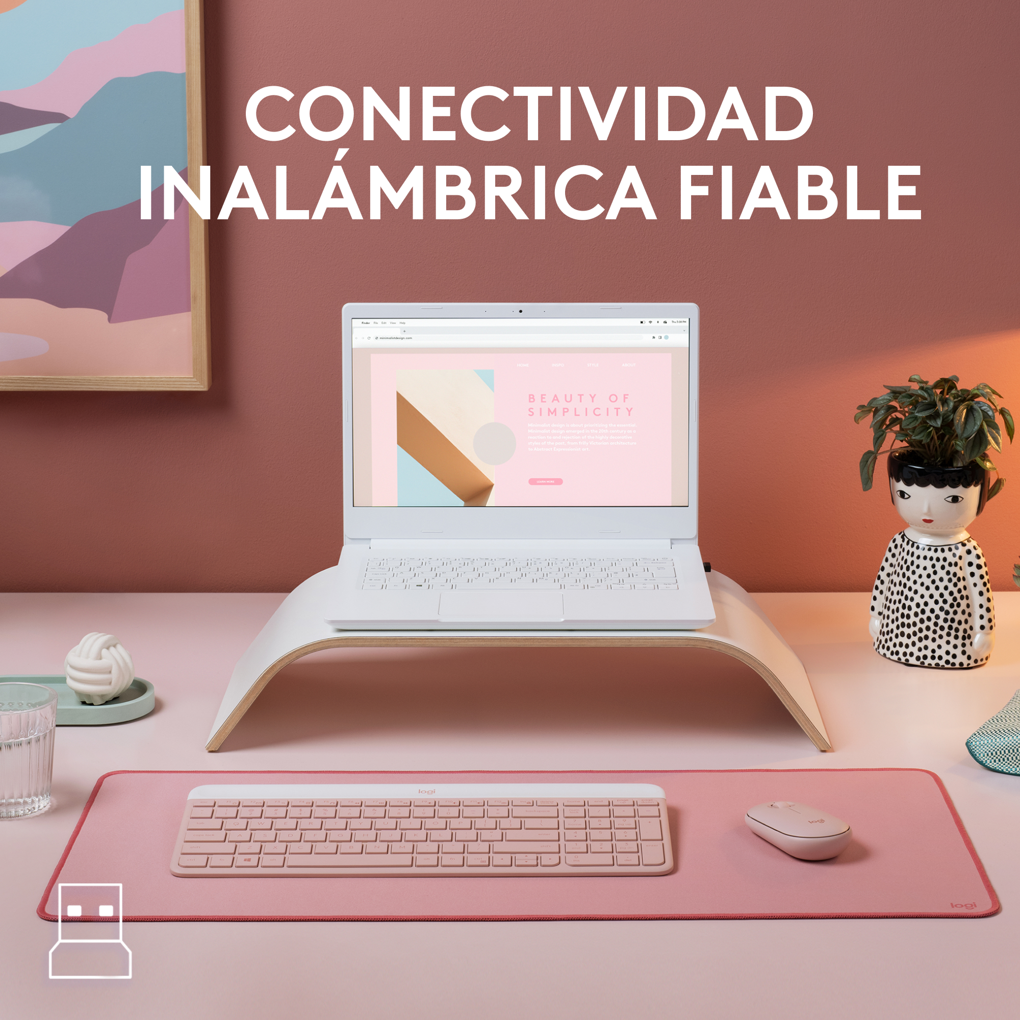 Un escritorio con una computadora portátil, teclado, mouse y una planta decorativa. Fondo rosa.