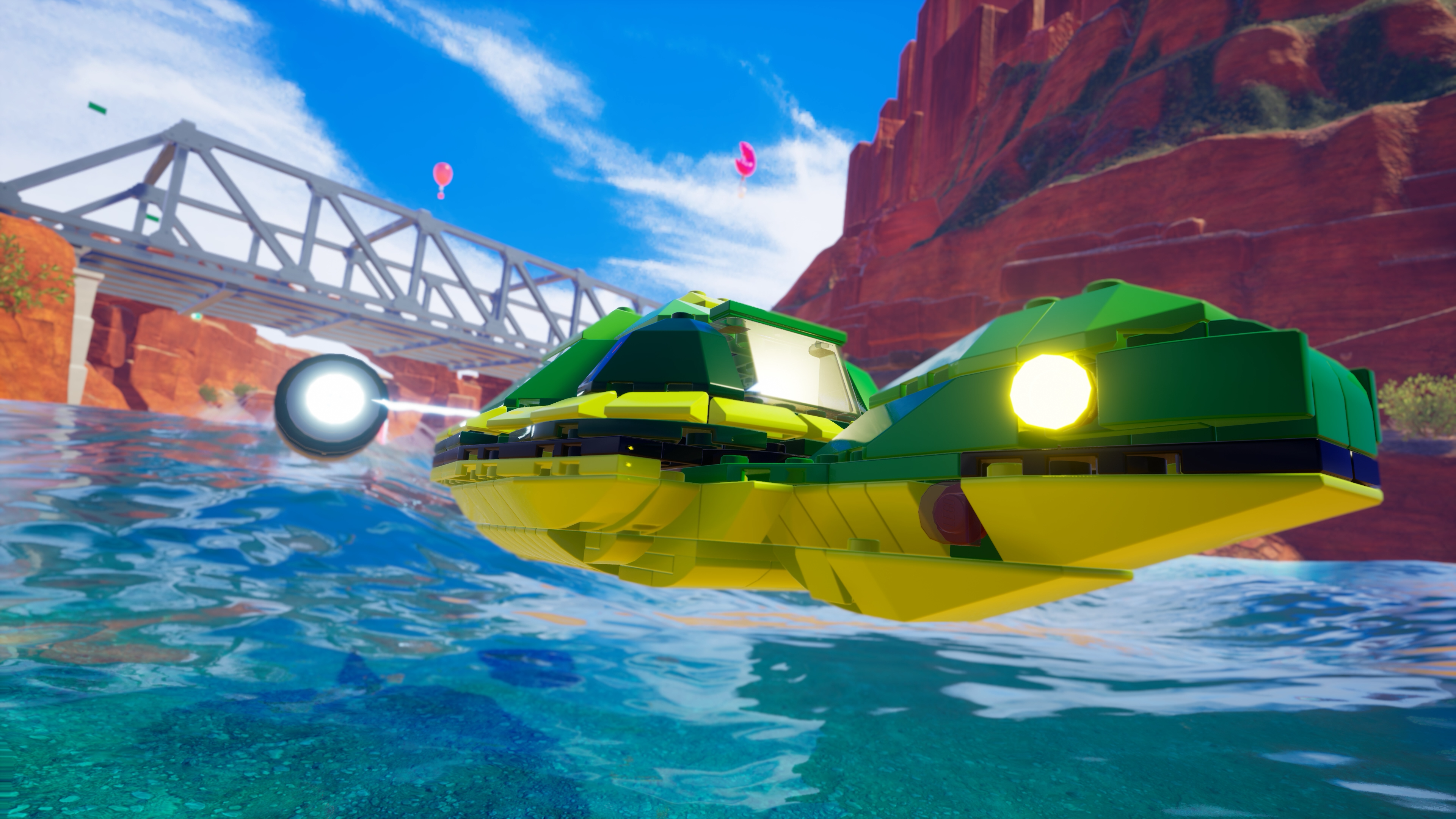 Lego-Boot auf Wasser mit Brücke und Bergen im Hintergrund. Blauer Himmel und Wasser.