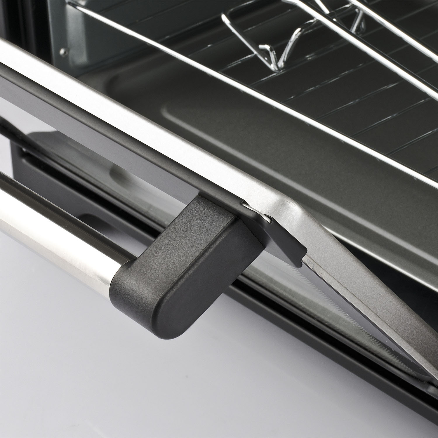 Forno aperto con maniglia a destra. Griglie metalliche e interno visibili. Sfondo bianco.