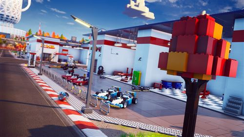 Una escena de la ciudad de Lego con coches de carreras, una tienda y una estructura alta y colorida.