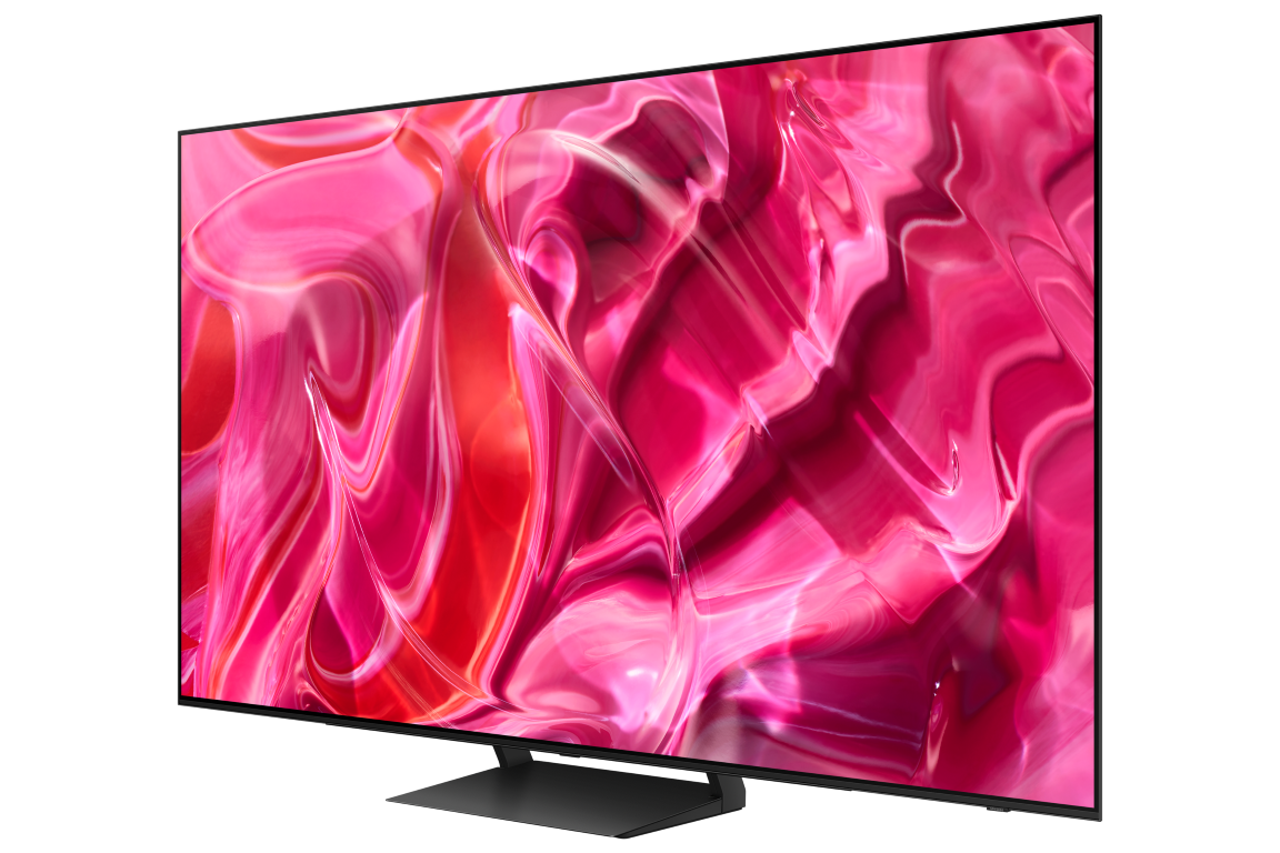 Siyah bir stand üzerinde pembe, soyut bir tasarım sergileyen büyük, modern bir TV ekranı.