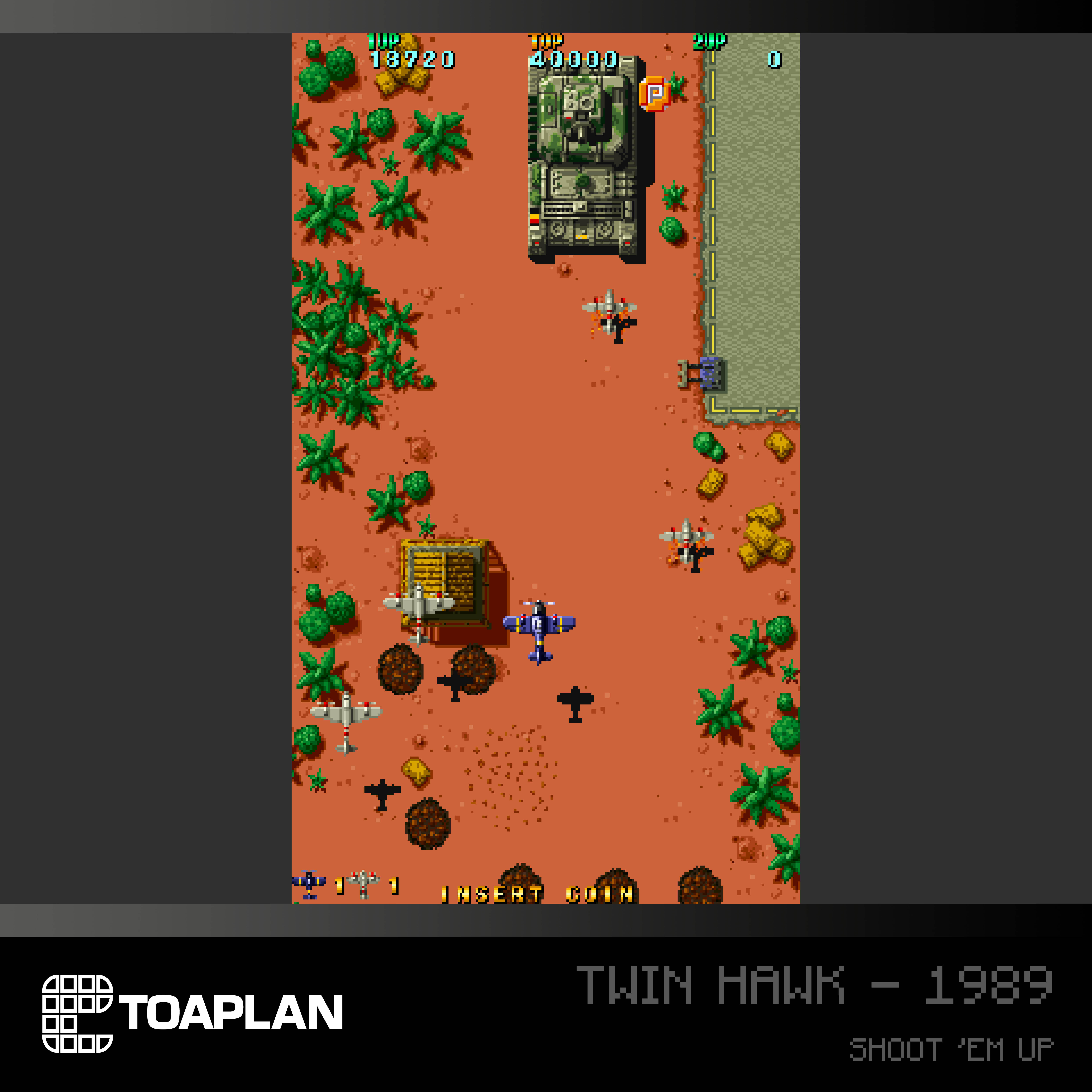 Eine Draufsicht auf ein klassisches Arcade-Spiel: Twin Hawk - 1989. Flugzeuge und Panzer in einer Wüstenszene.