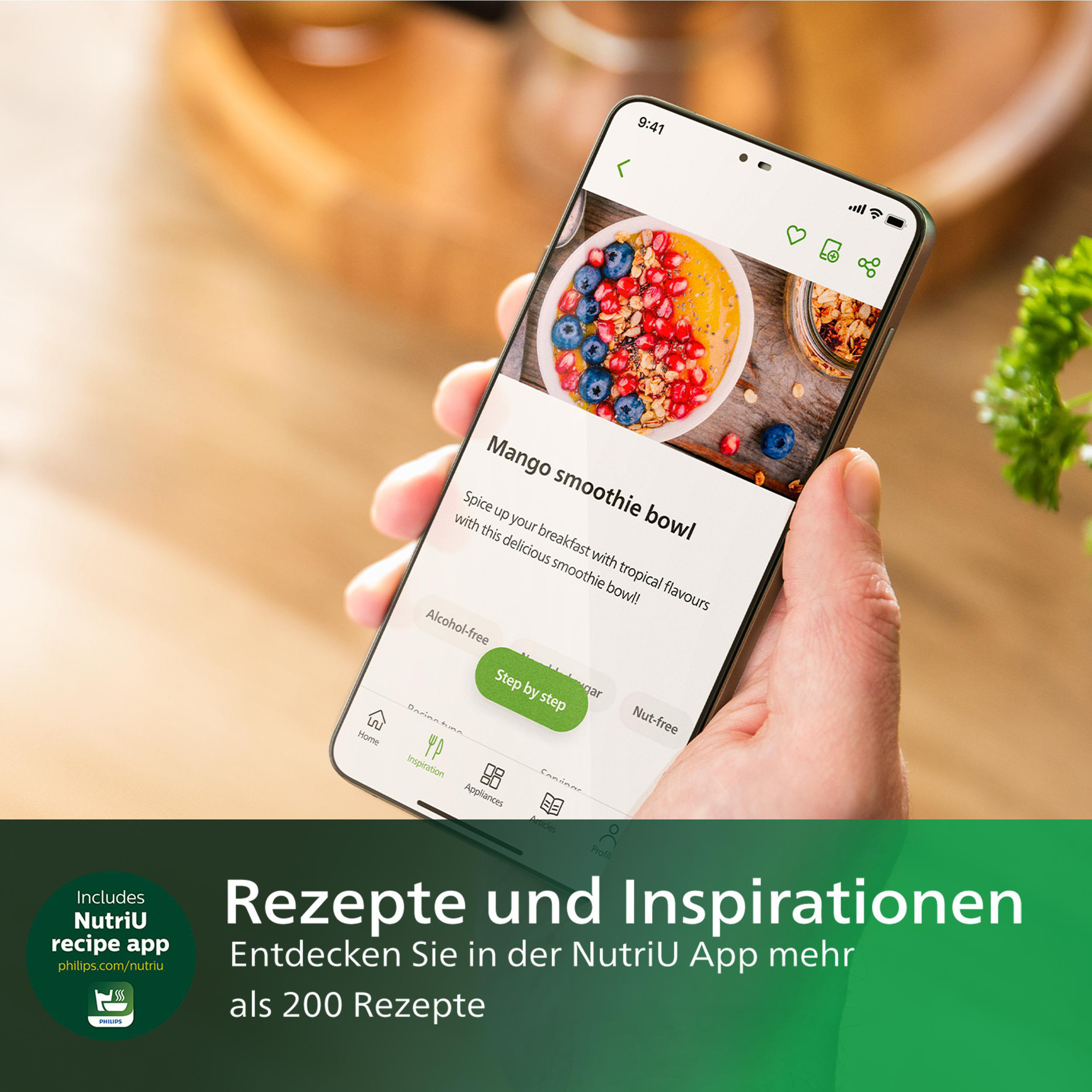 Eine Hand, die ein Telefon hält, auf dem eine Rezept-App für eine Mango-Smoothie-Bowl angezeigt wird. Text: Rezepte und Inspiration.