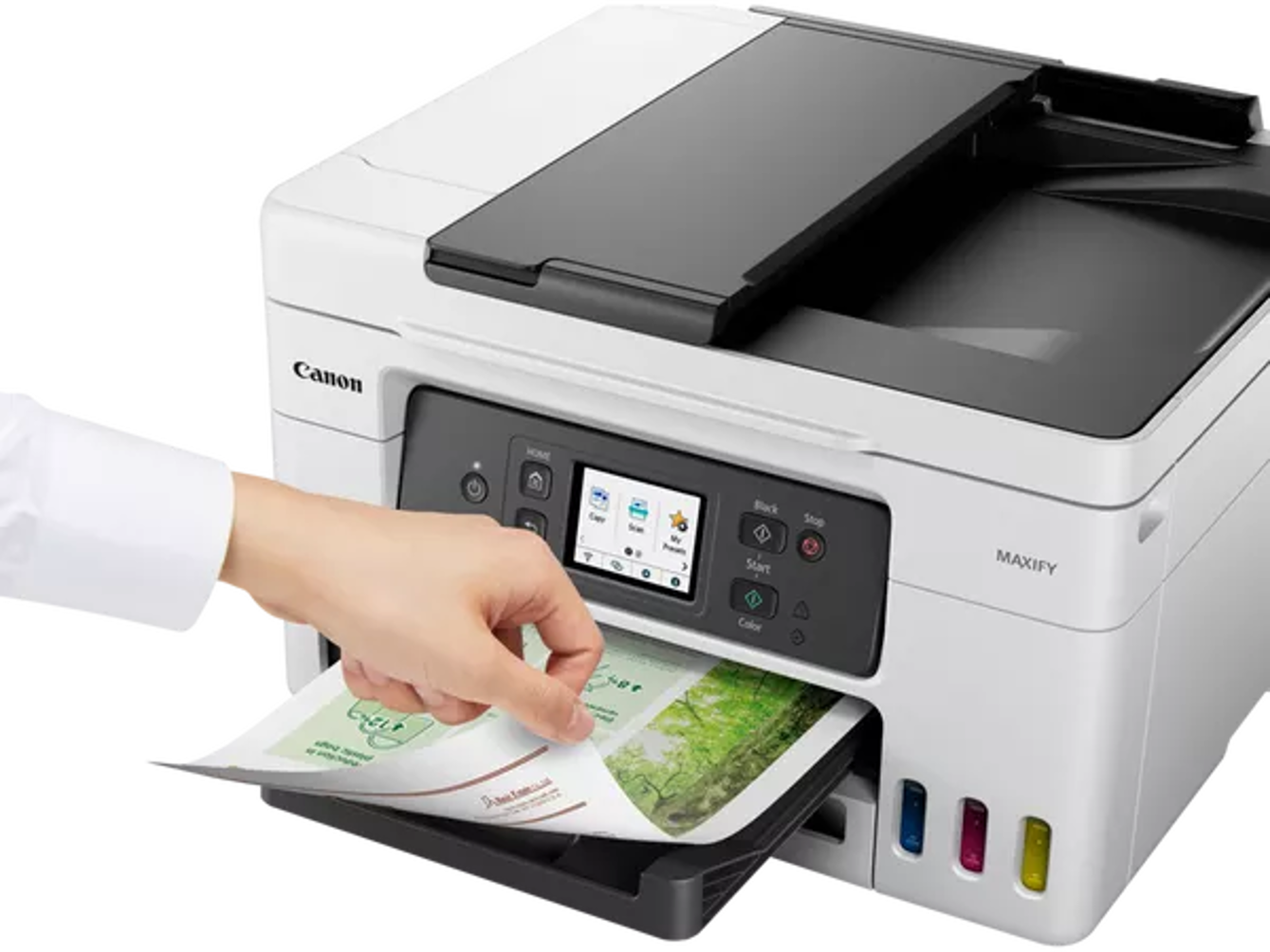 Persona che inserisce carta in una stampante Canon bianca con display touchscreen.