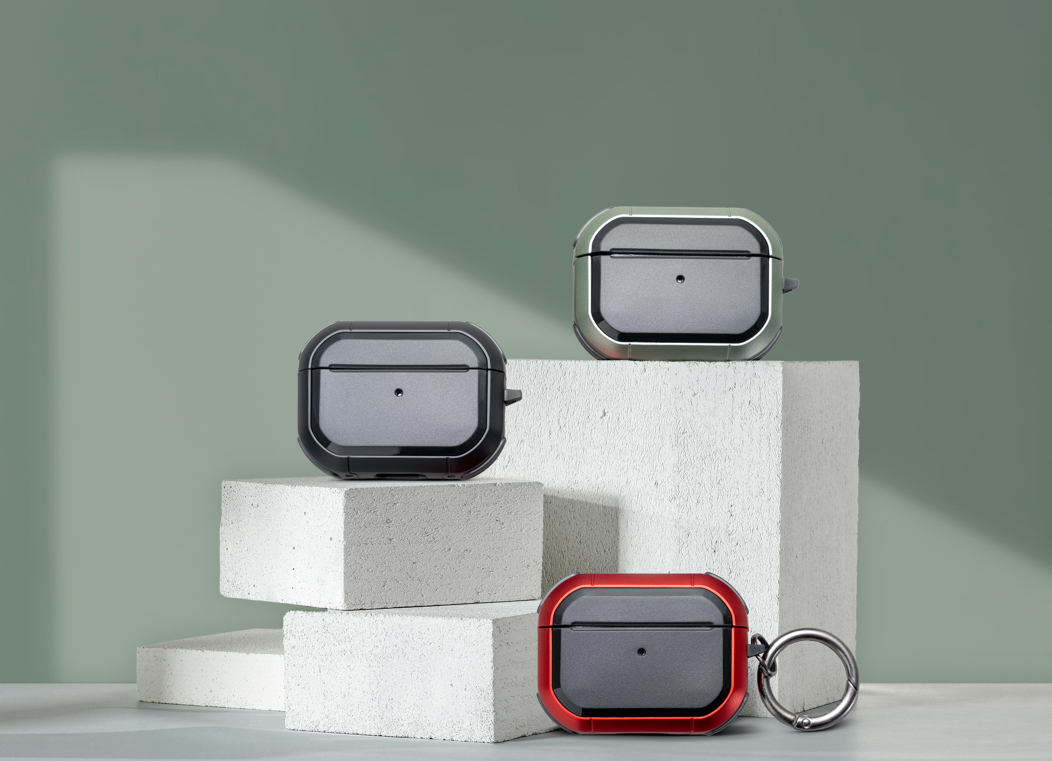 Drei Schutzhüllen für Airpods Pro in verschiedenen Farben, auf weißen Blöcken vor grünem Hintergrund ausgestellt.