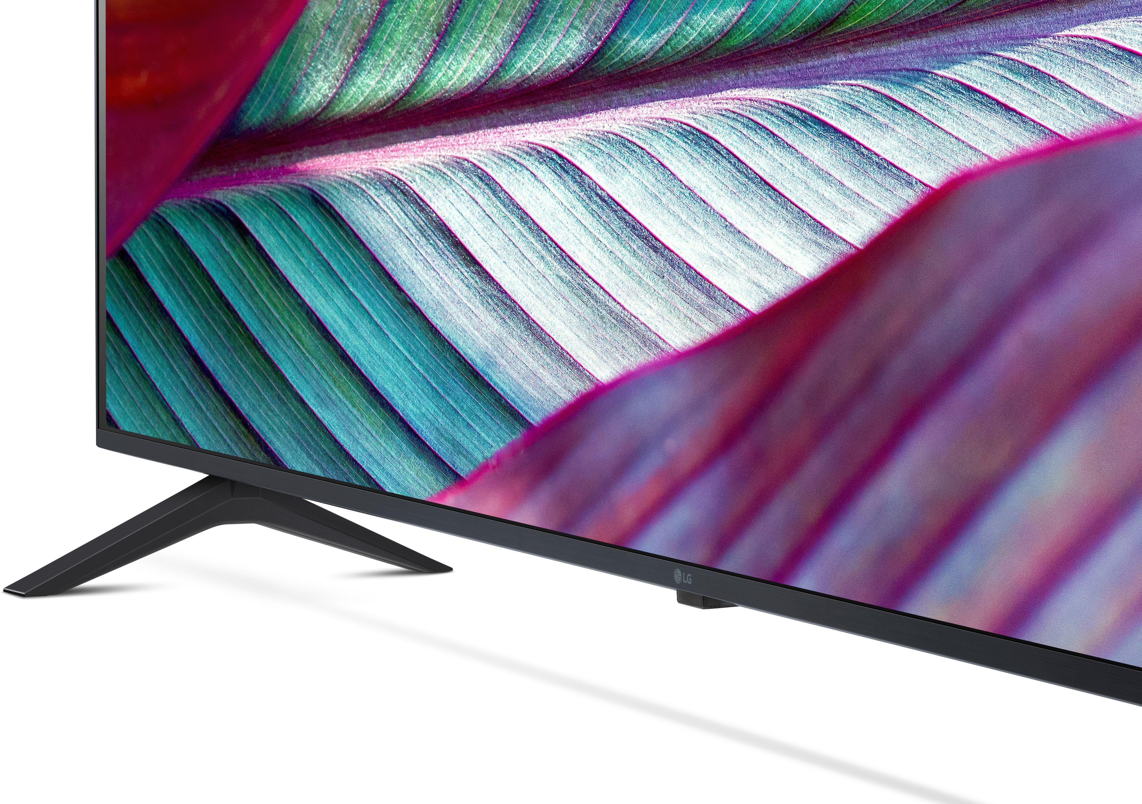 Nahaufnahme eines schwarzen Fernsehers mit Ständer. Bunter Blätterhintergrund.