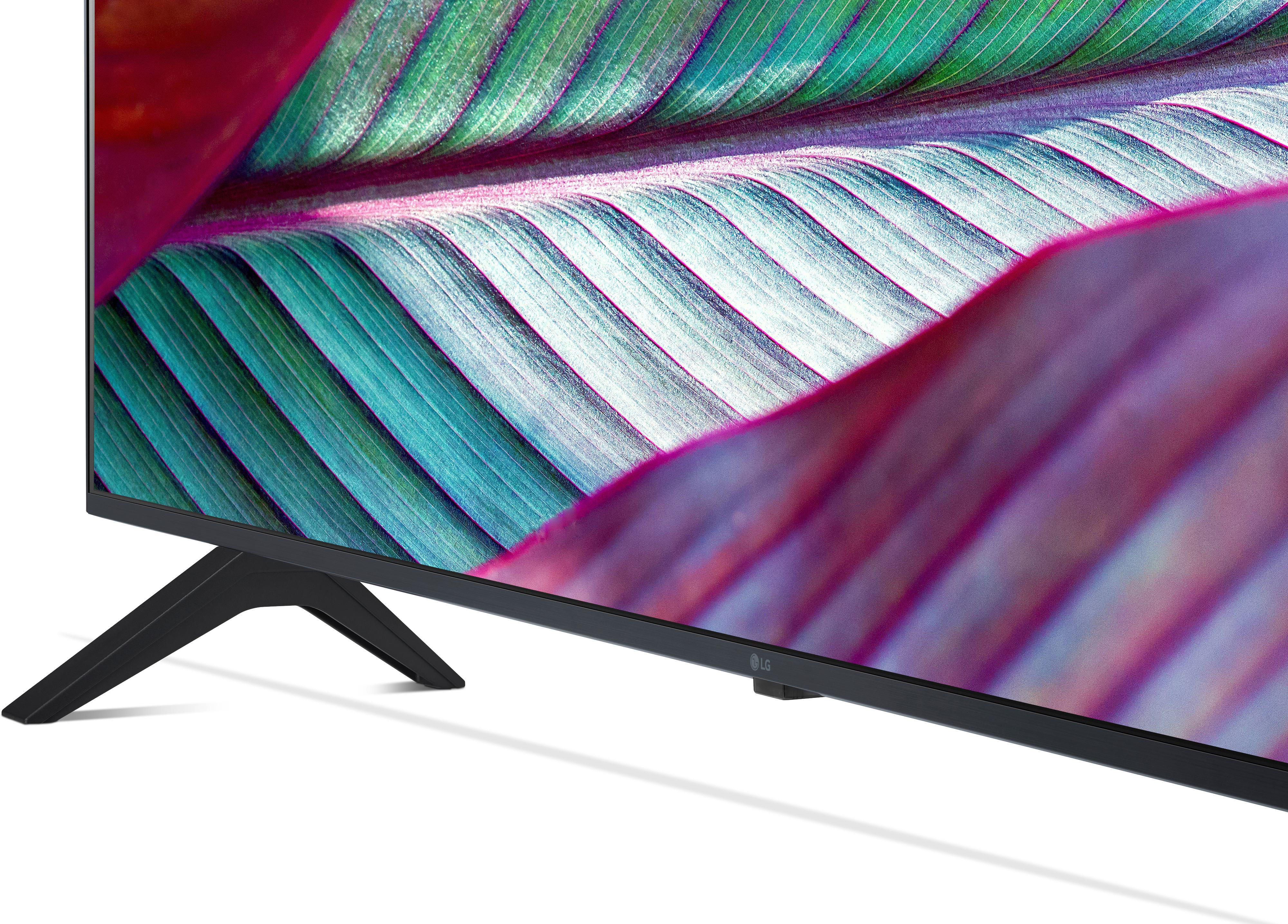 LG-Fernseher mit Blättermuster auf dem Bildschirm. Schwarzer Rahmen und Ständer. Weißer Hintergrund.