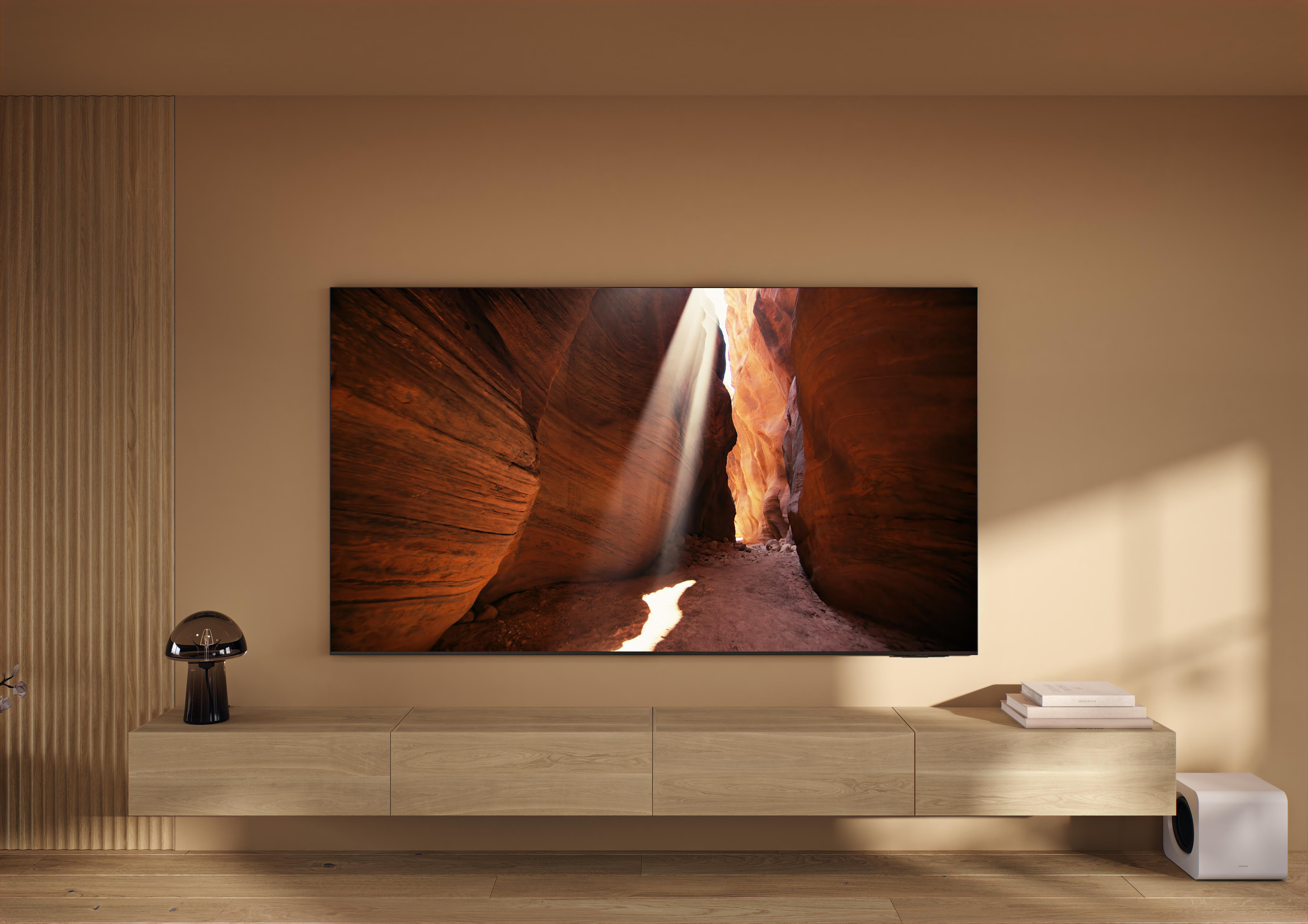 Ein modernes Wohnzimmer mit einem Fernseher an der Wand, Licht scheint durch eine Schluchtszene auf dem Bildschirm.
