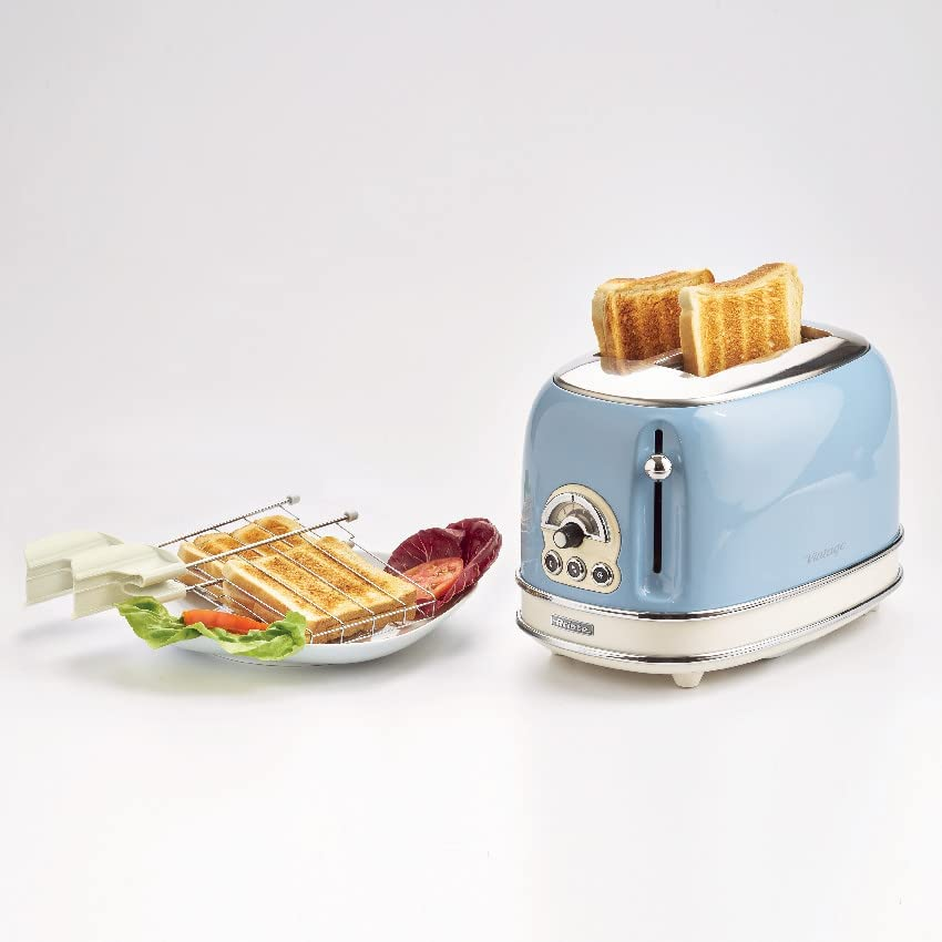 Blauer Retro-Toaster mit zwei Toastscheiben. Ein Teller mit Toast und Gemüse daneben.