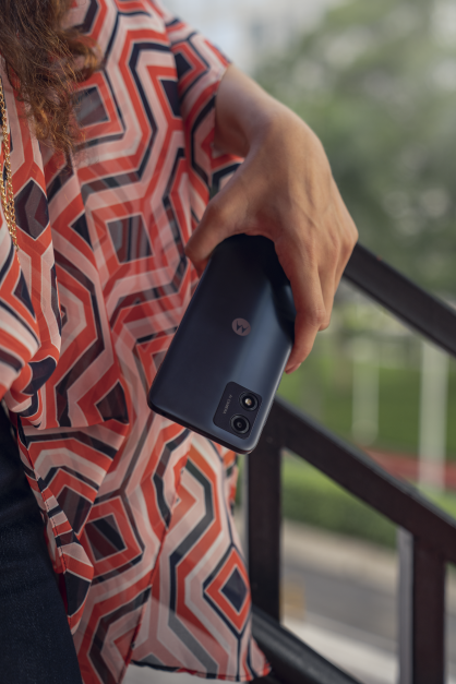 Egy személy egy fekete Motorola okostelefont tart. A telefon kifelé néz, a hátulját és a kamerát mutatva.