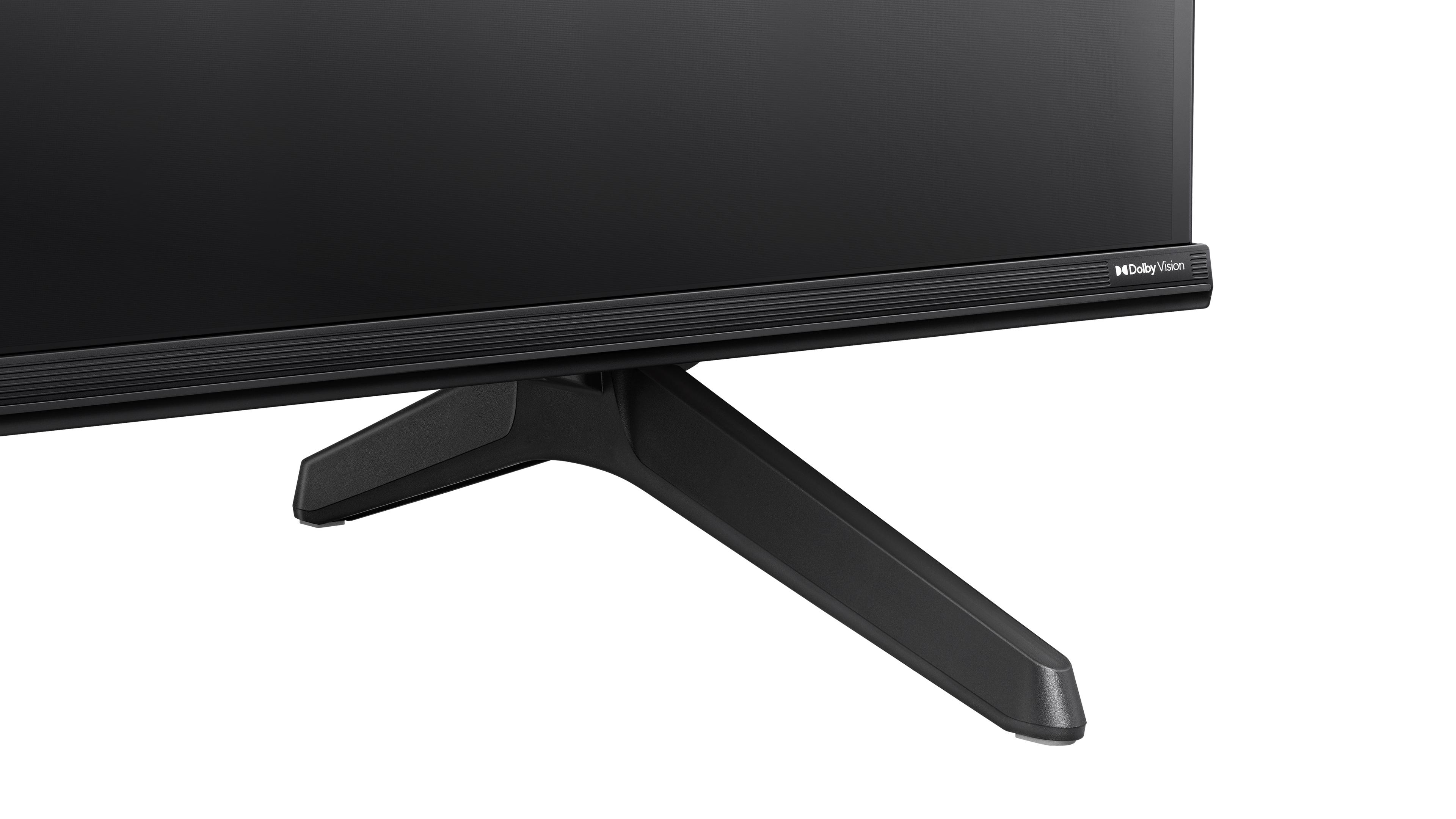Schwarzer Fernseher mit zwei schwarzen Beinen. Der Fernseher steht vor weißem Hintergrund.