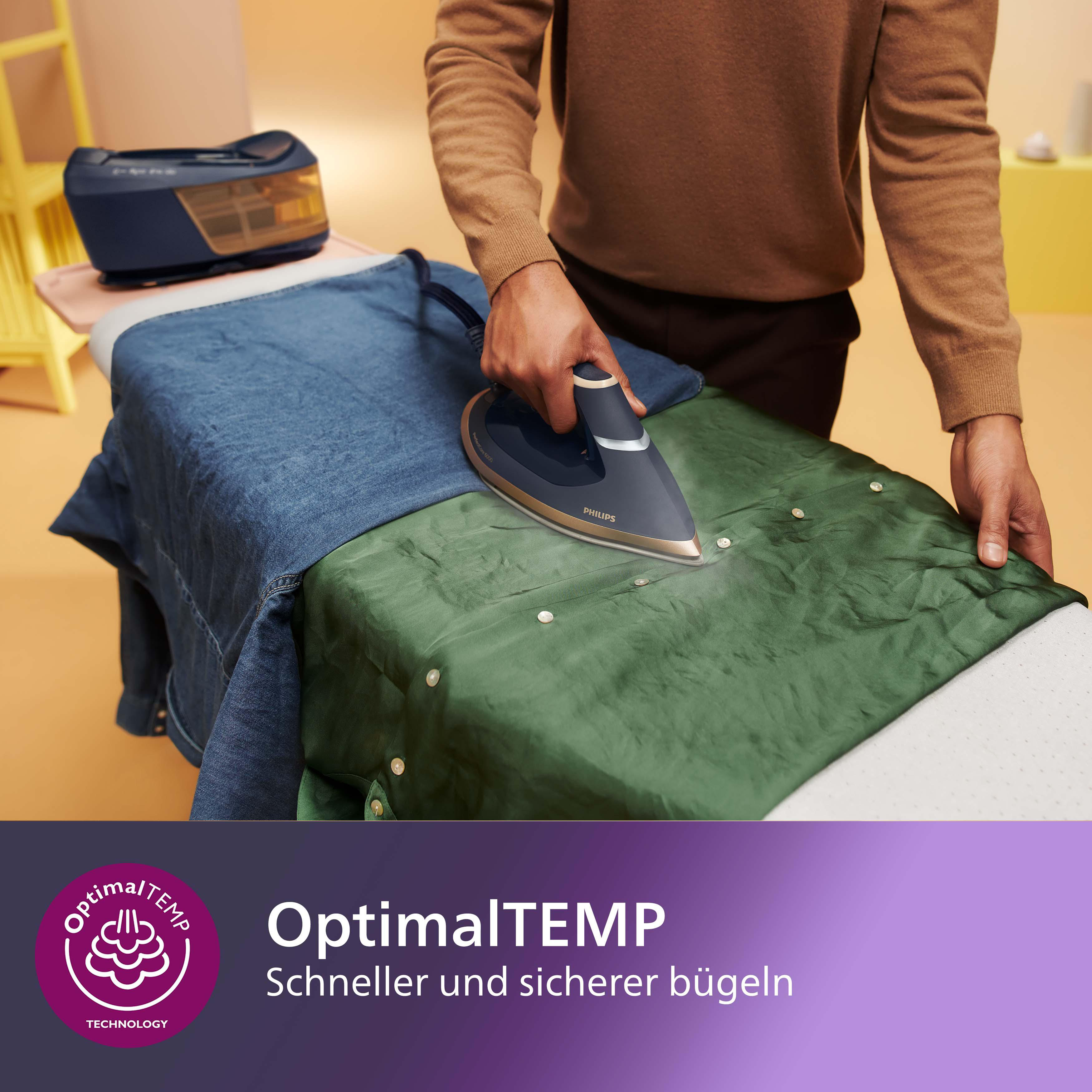 Eine Person, die ein grünes Hemd auf einem Bügelbrett bügelt, mit einem blauen Bügeleisen und einem blauen und gelben Dampfgenerator.