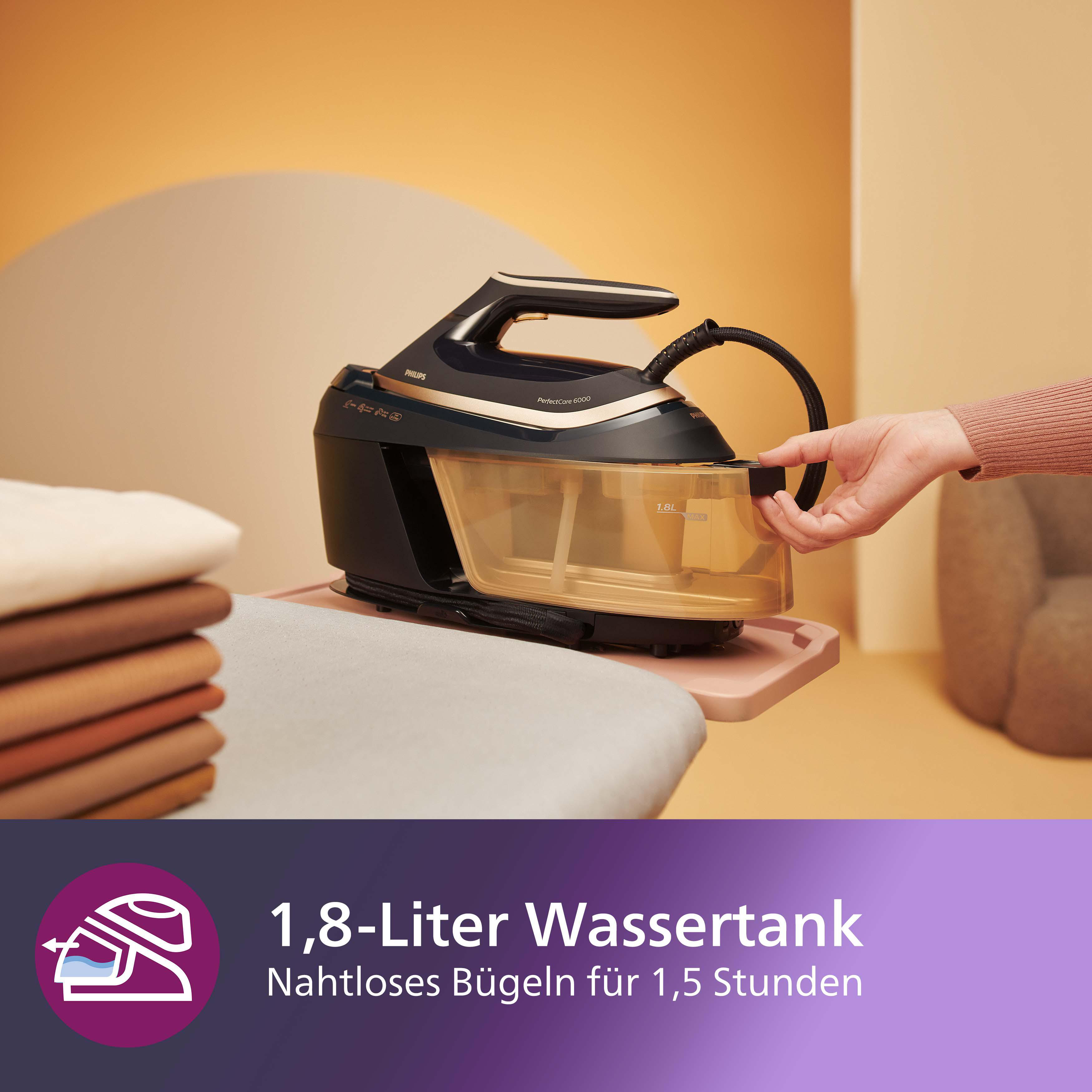 Ein schwarzes und goldenes Bügeleisen mit Wassertank auf rosa Oberfläche.