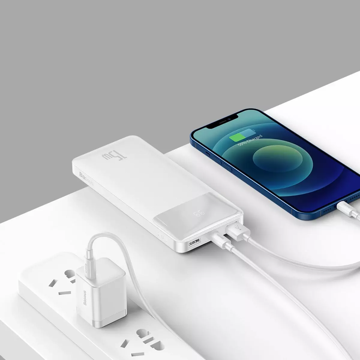 Beyaz bir güç bankası bir kabloyla bir telefonu şarj ediyor.
