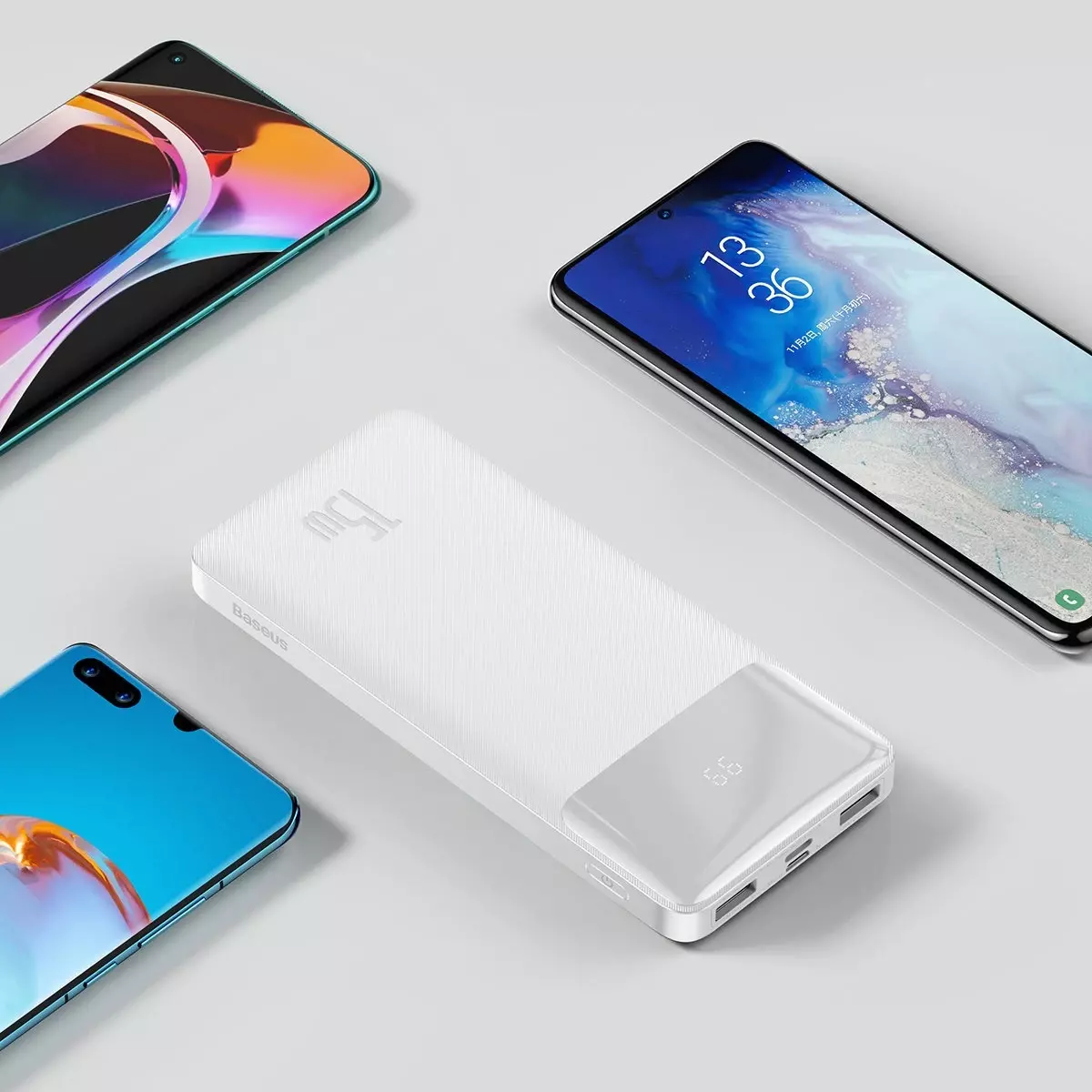 Arka planda telefonlarla beyaz güç bankası. Üç telefon görünür.