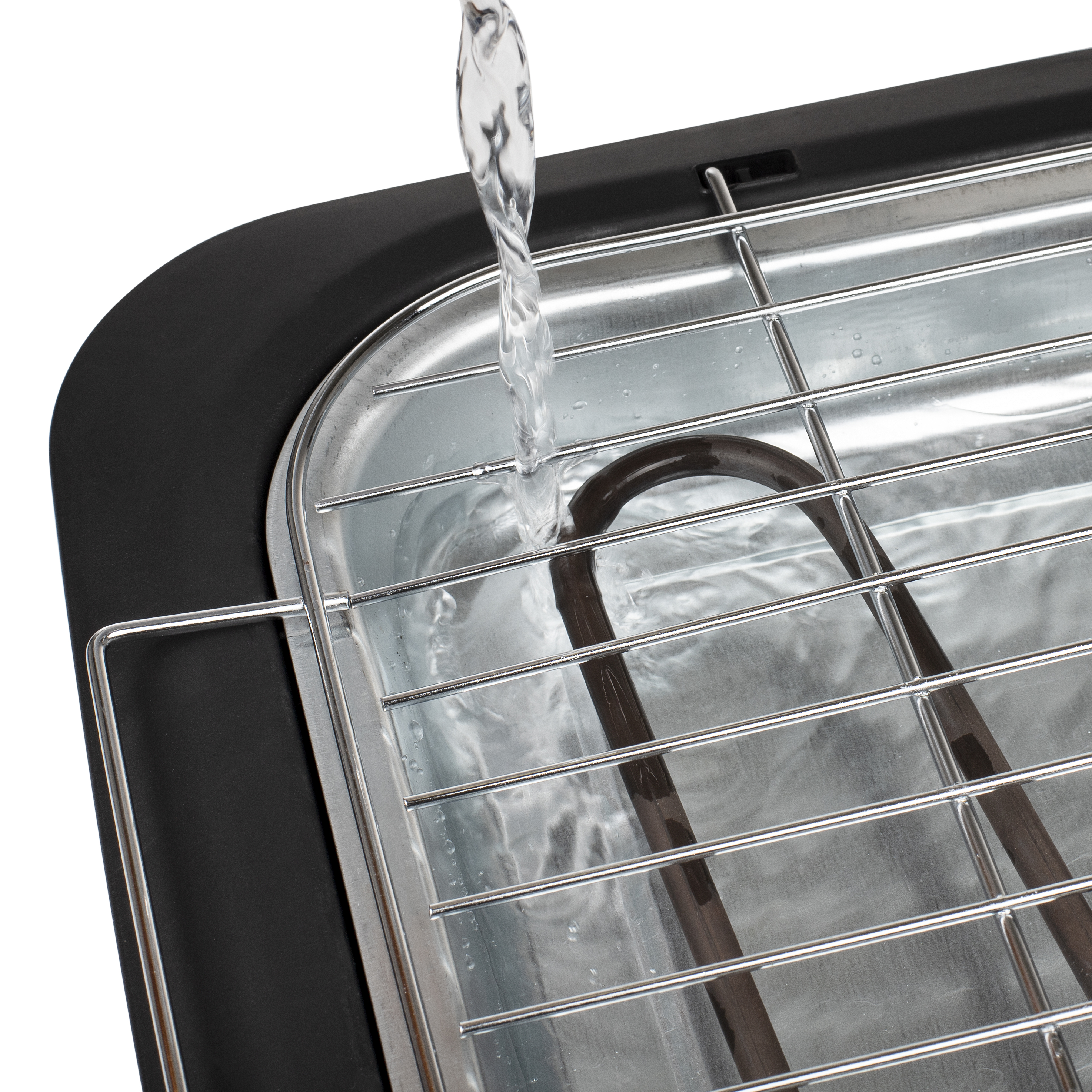 Agua vertiéndose en una parrilla eléctrica negra con rejilla metálica y elemento calefactor.