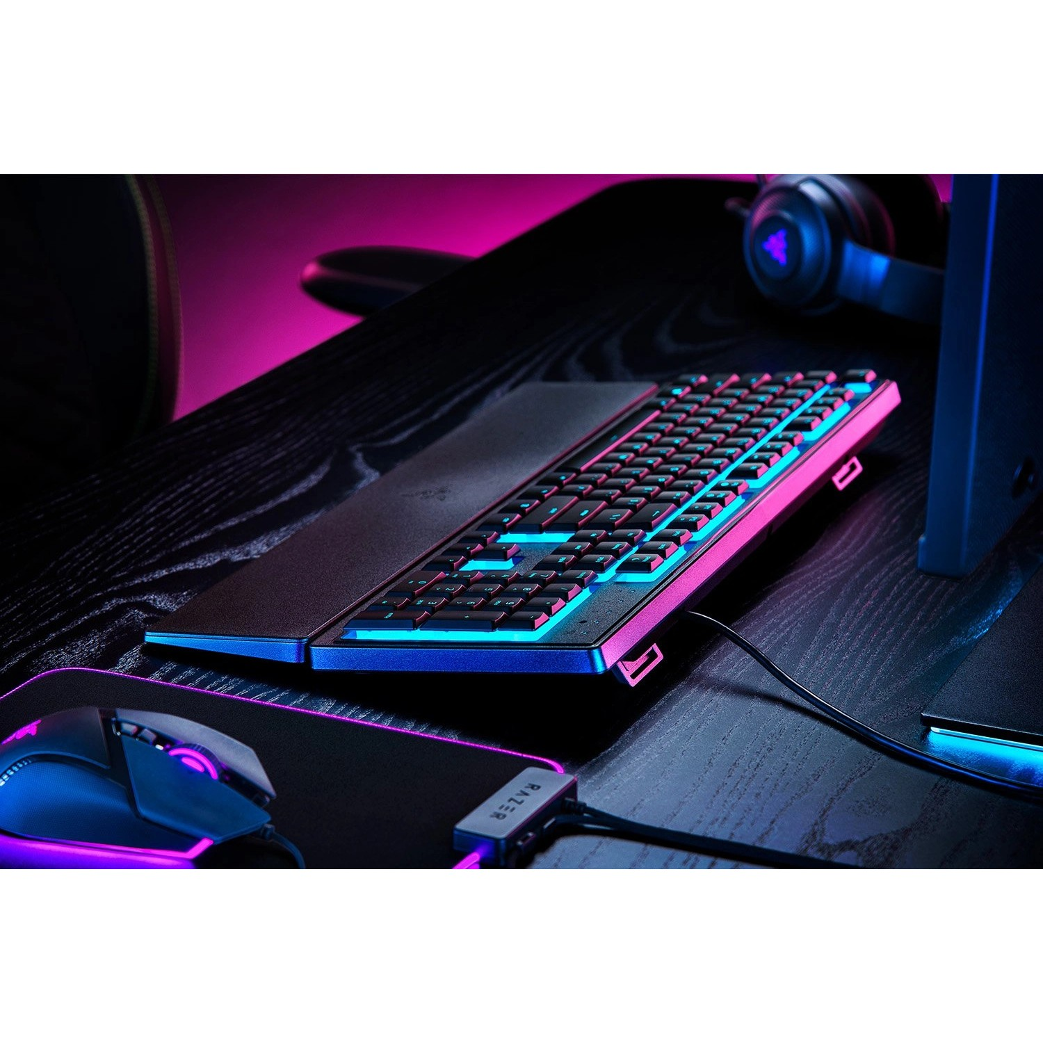 Gaming setup with a keyboard and mouse. RGB lighting is present. Headphones visible.