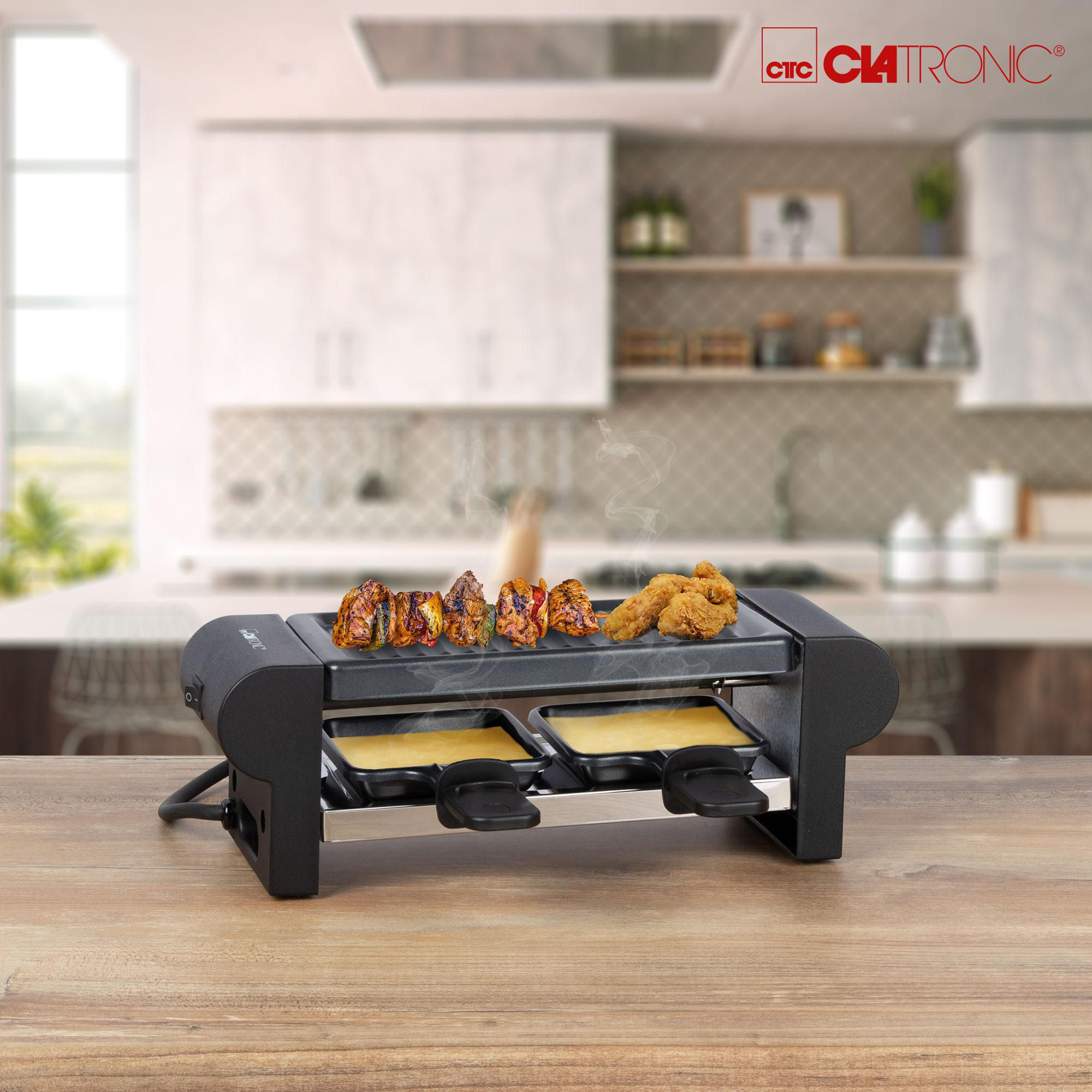 Schwarzer Raclette-Grill mit Essen, das gekocht wird, Holztisch, mit Küchenhintergrund.
